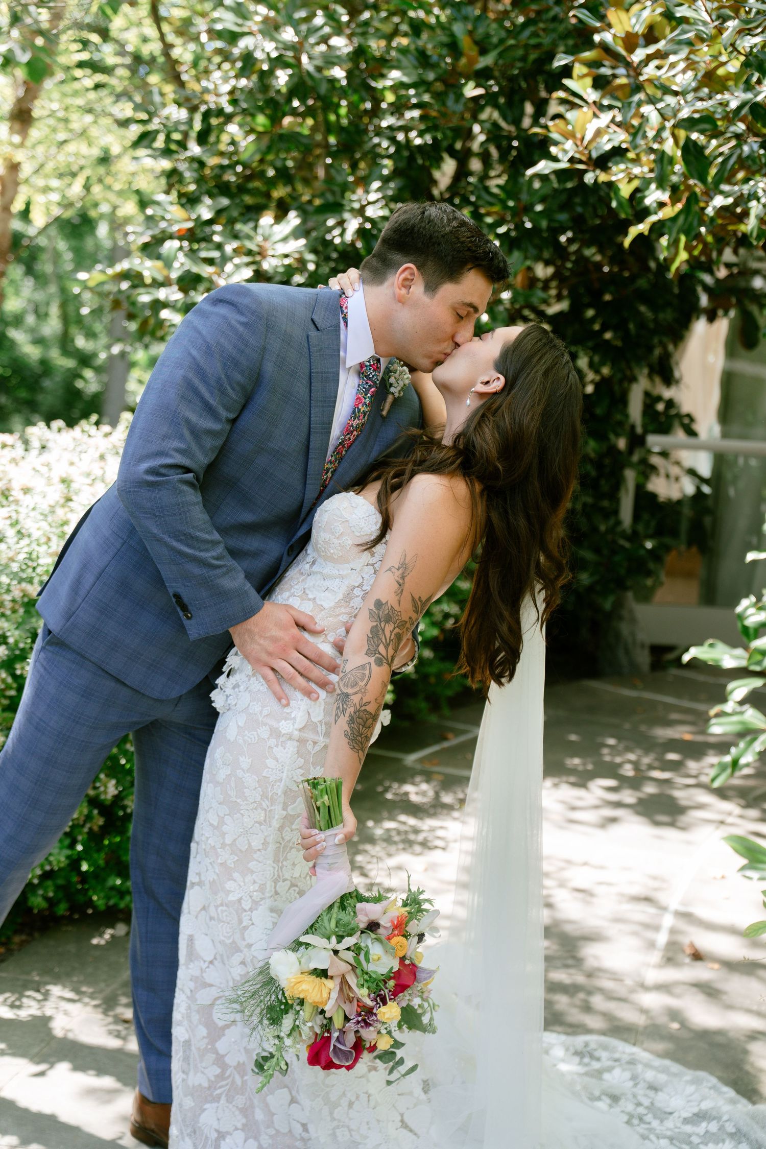 Couple shares intimate moments during their wedding photoshoot in a lush garden setting.