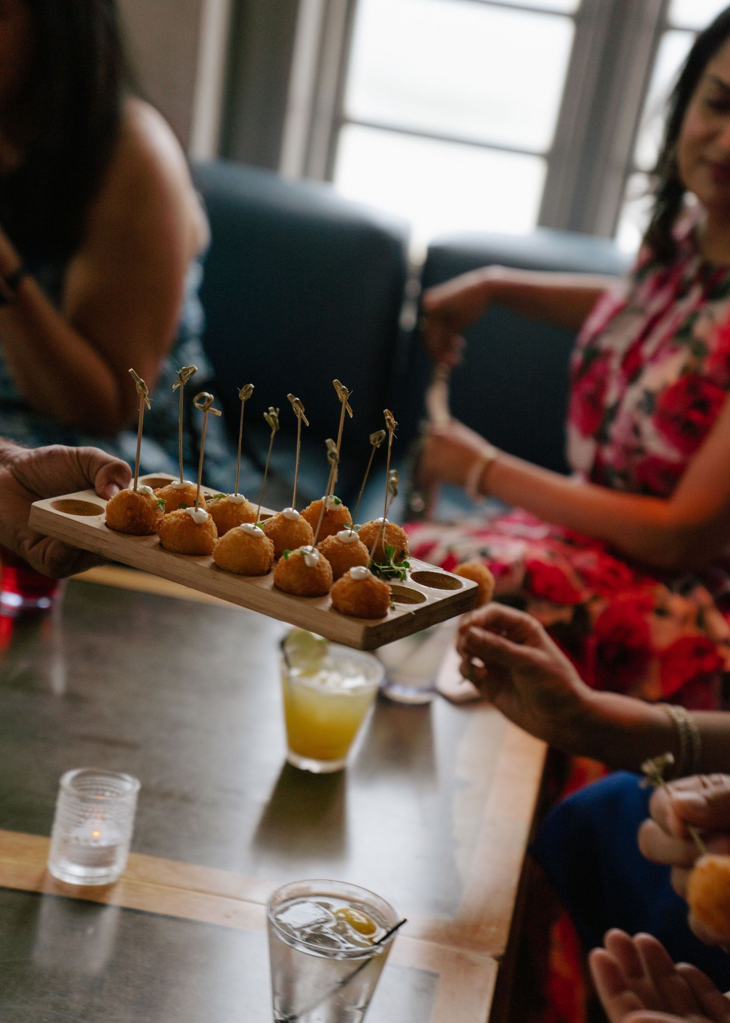 Appetizer platter of small bites with cocktails being served at a party.