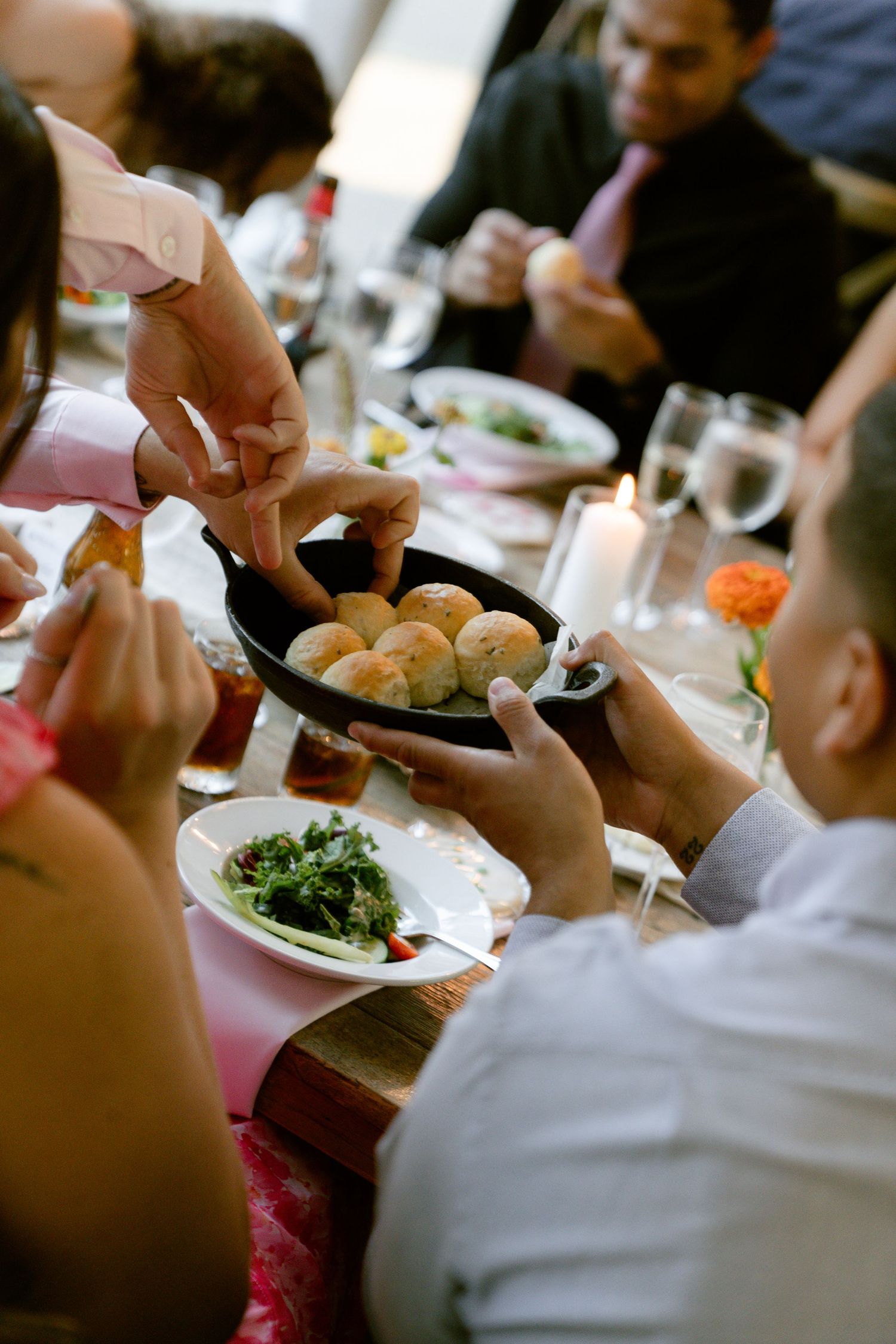 Wedding reception dinner service showing plates of food being passed among guests.