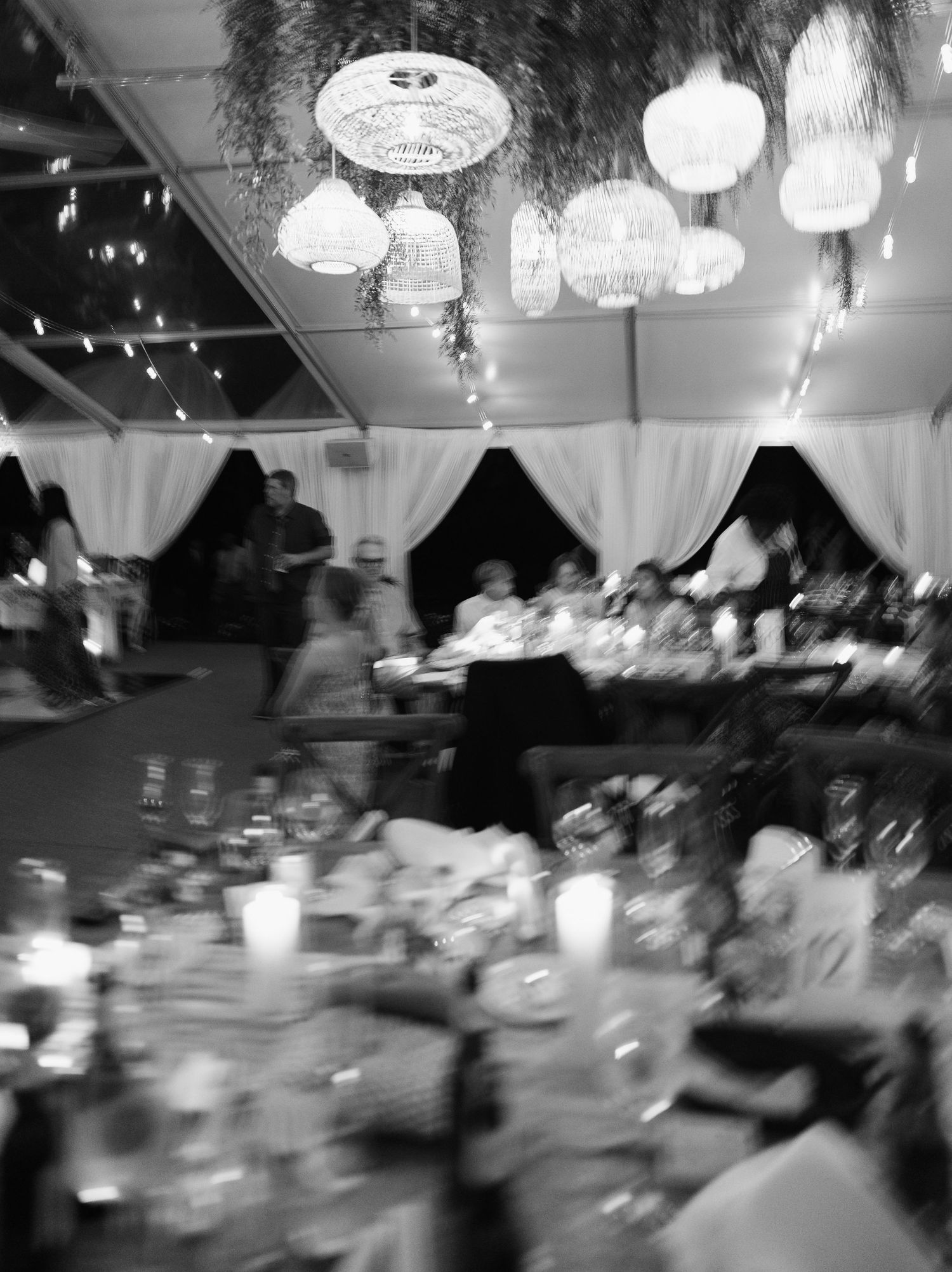 Black and white motion blur images show a dimly lit reception hall with elegant chandeliers and table settings.