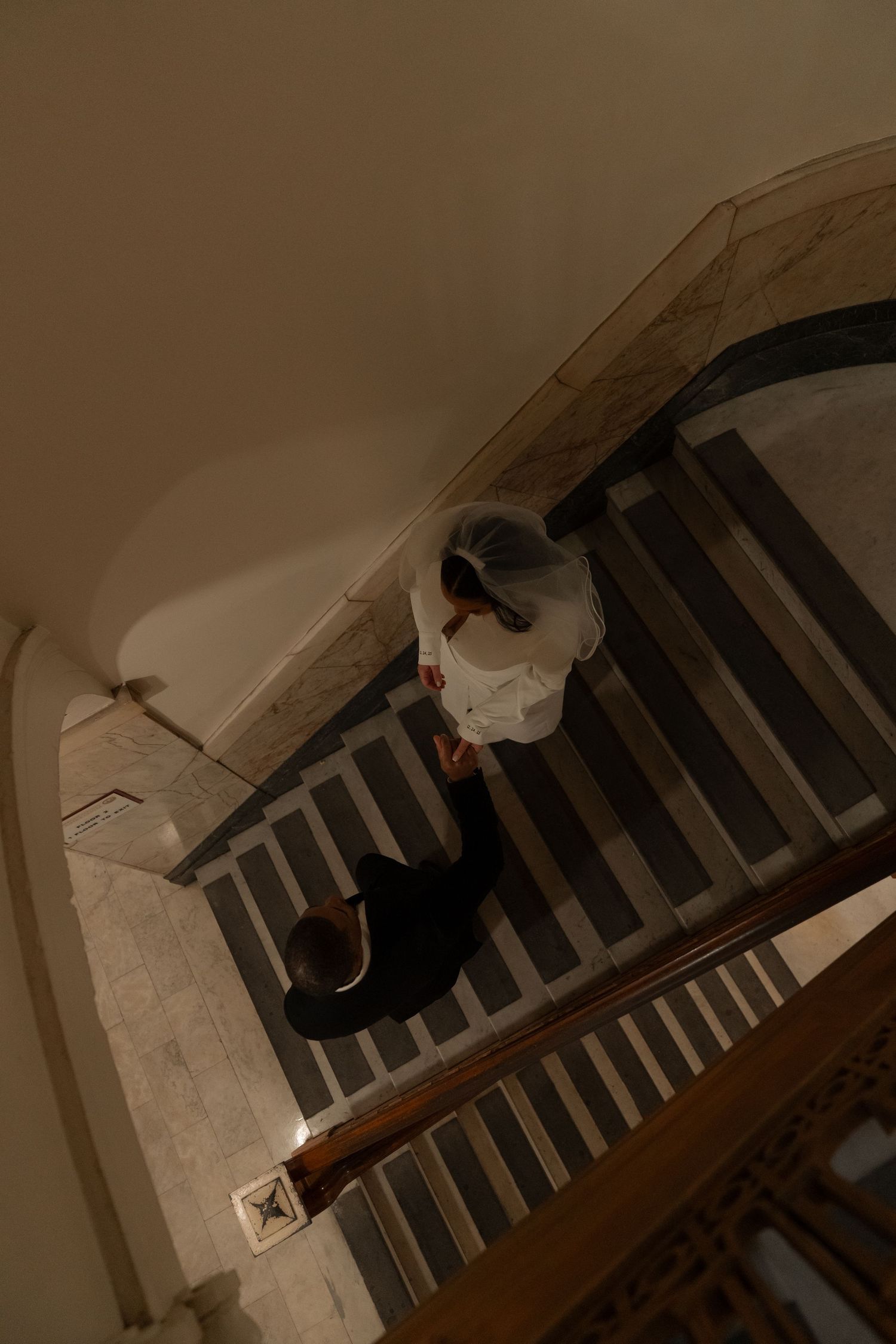 A dimly lit staircase with architectural details and dramatic shadows.