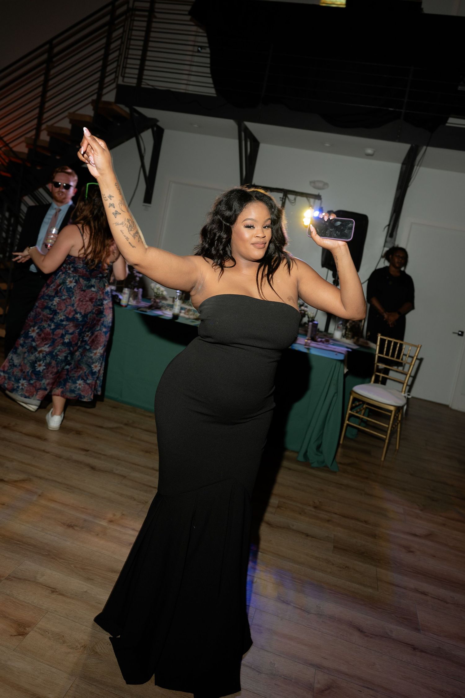 Wedding guests dancing and celebrating on wooden dance floor.