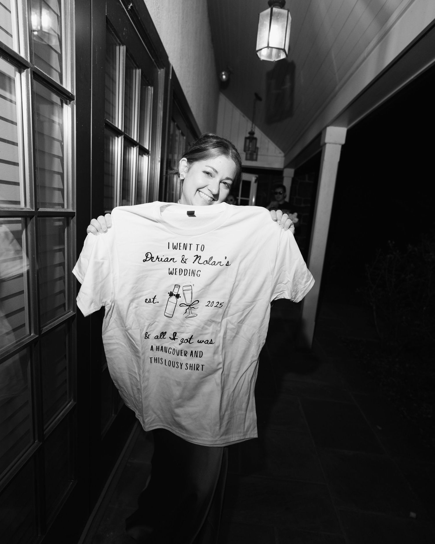 Black and white photos of custom wedding t-shirts displayed in a hallway.