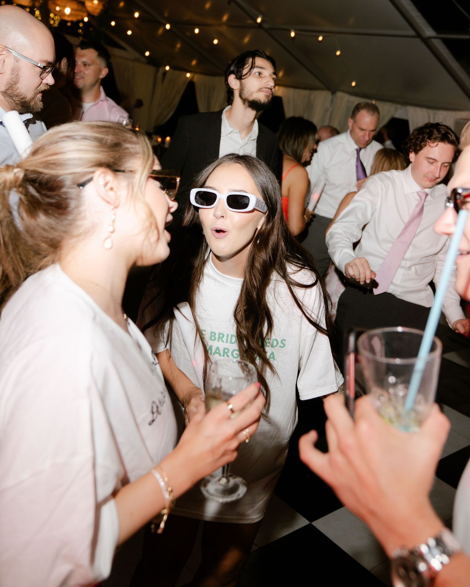 Lively dance party scene with string lights and guests enjoying the wedding reception.