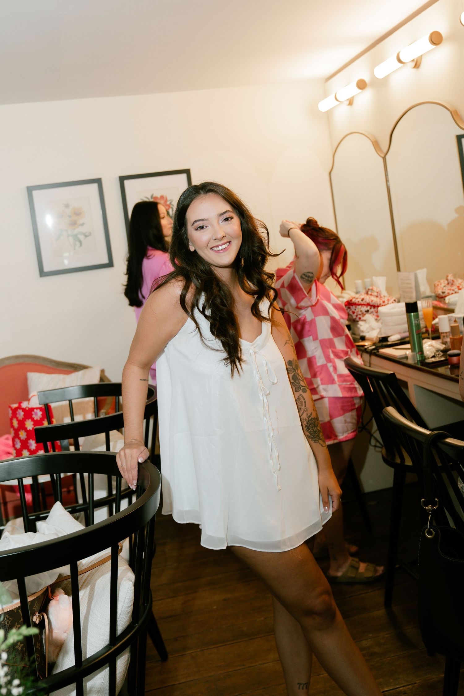 People dancing and celebrating at an indoor party with festive pink decorations.