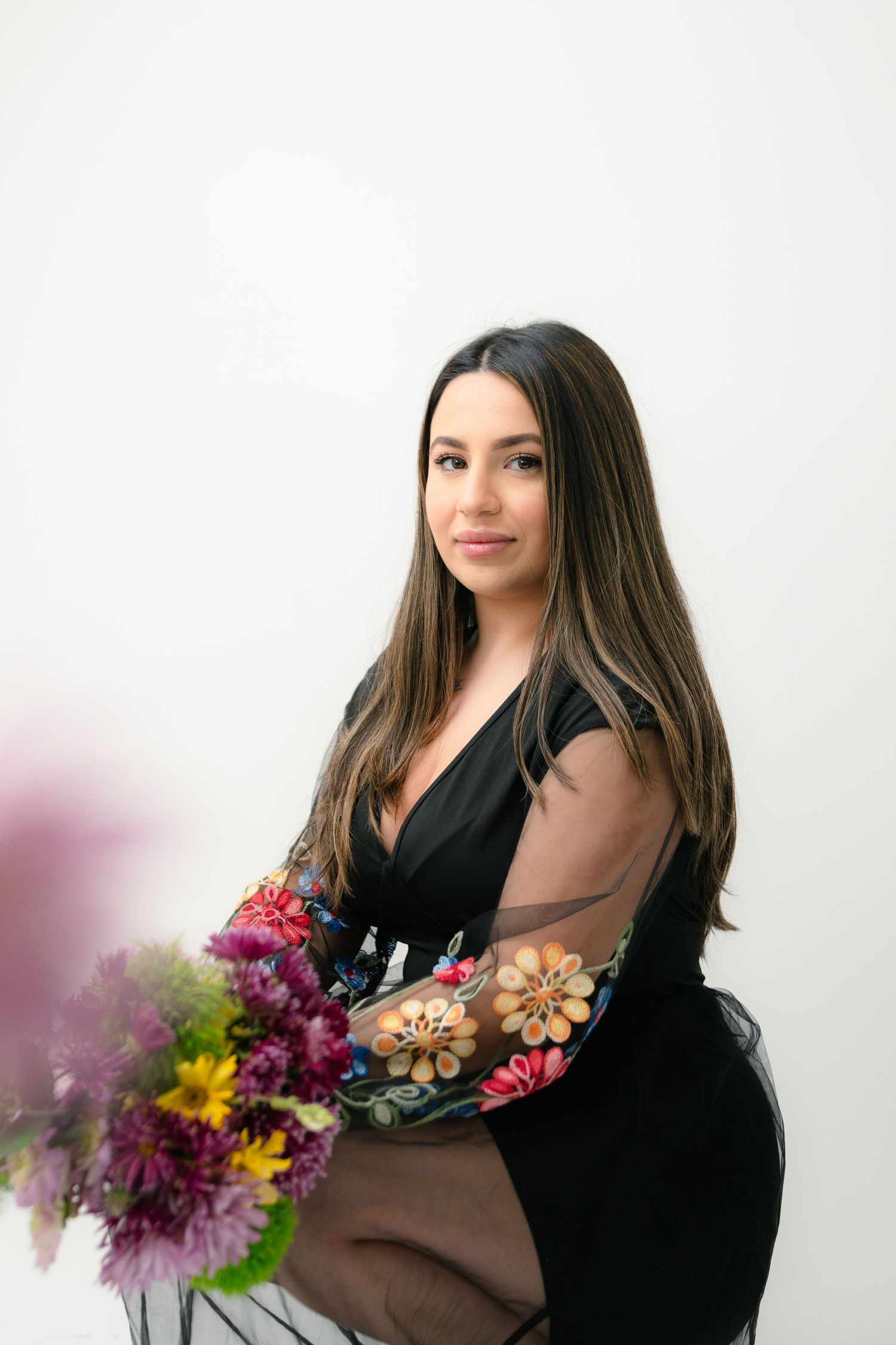 Studio portraits featuring colorful floral arrangements against a white background.