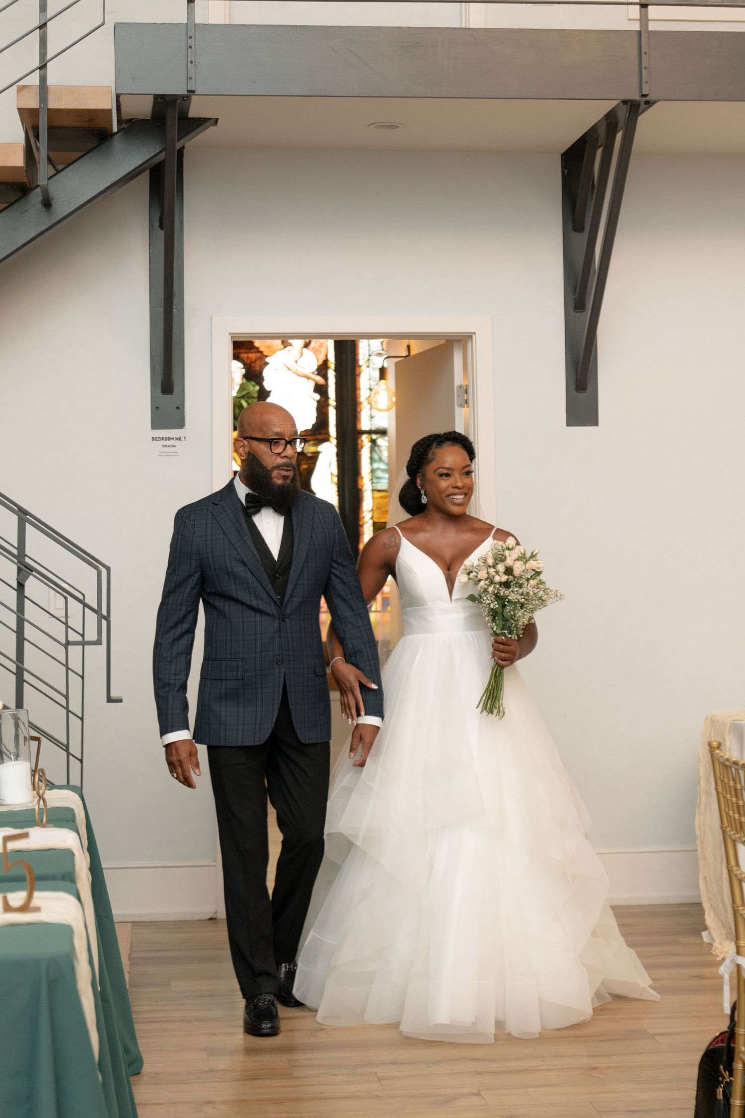 Wedding party entrance sequence in a modern venue with white walls and teal accents.