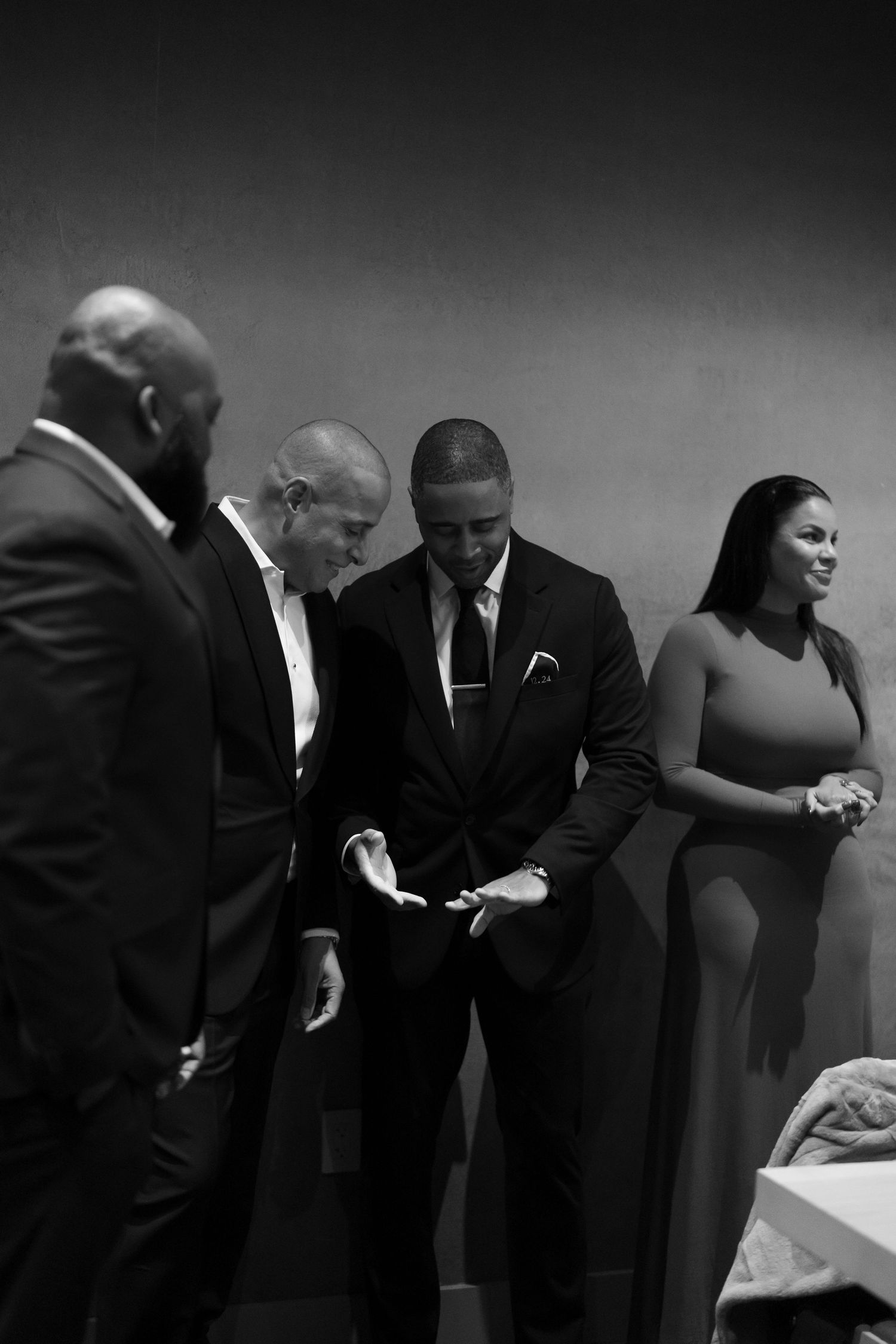 A black and white photo showing people in formal attire gathered in an indoor setting.