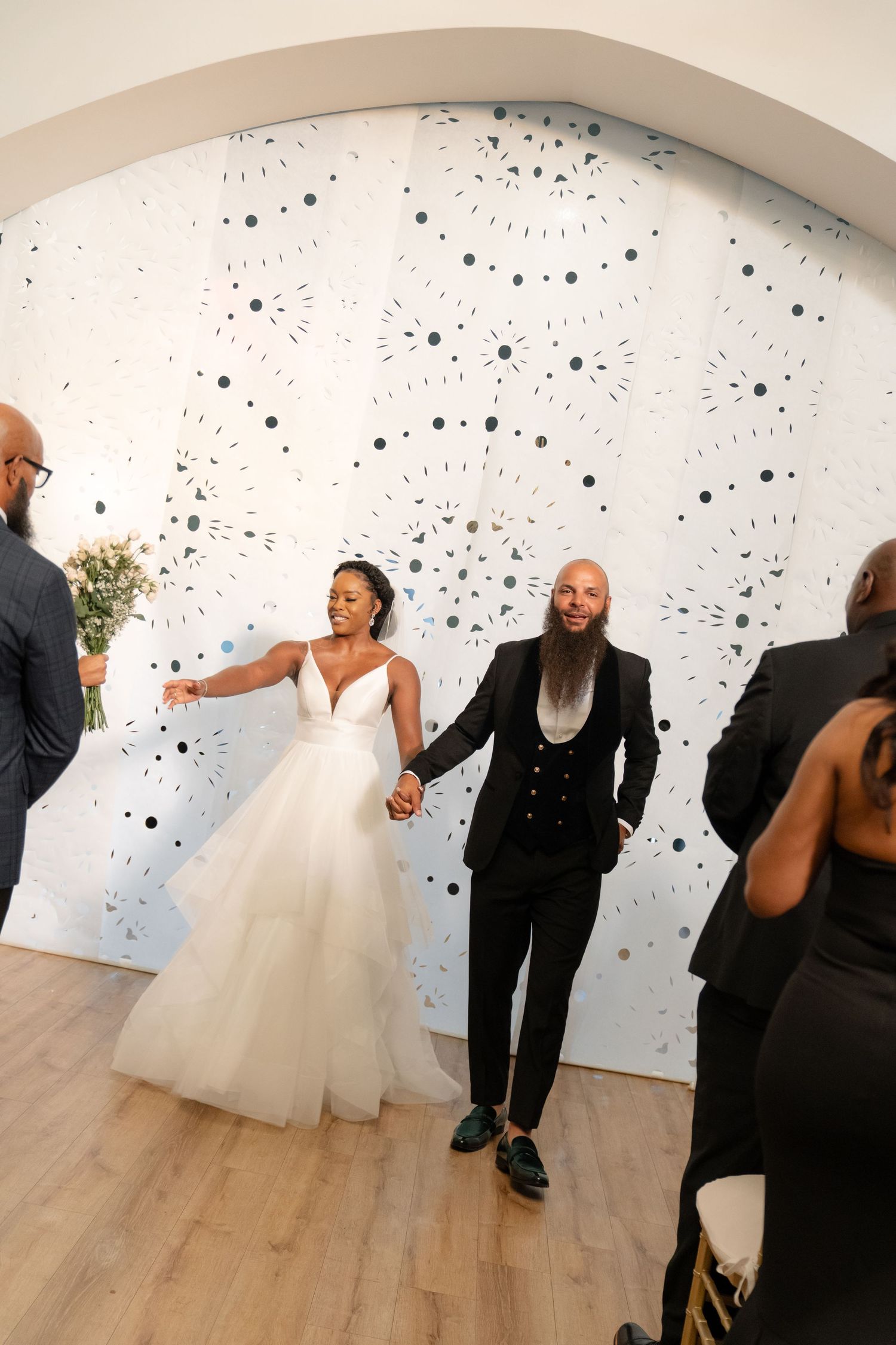 Wedding celebration in a modern gallery space with distinctive polka dot wall design.