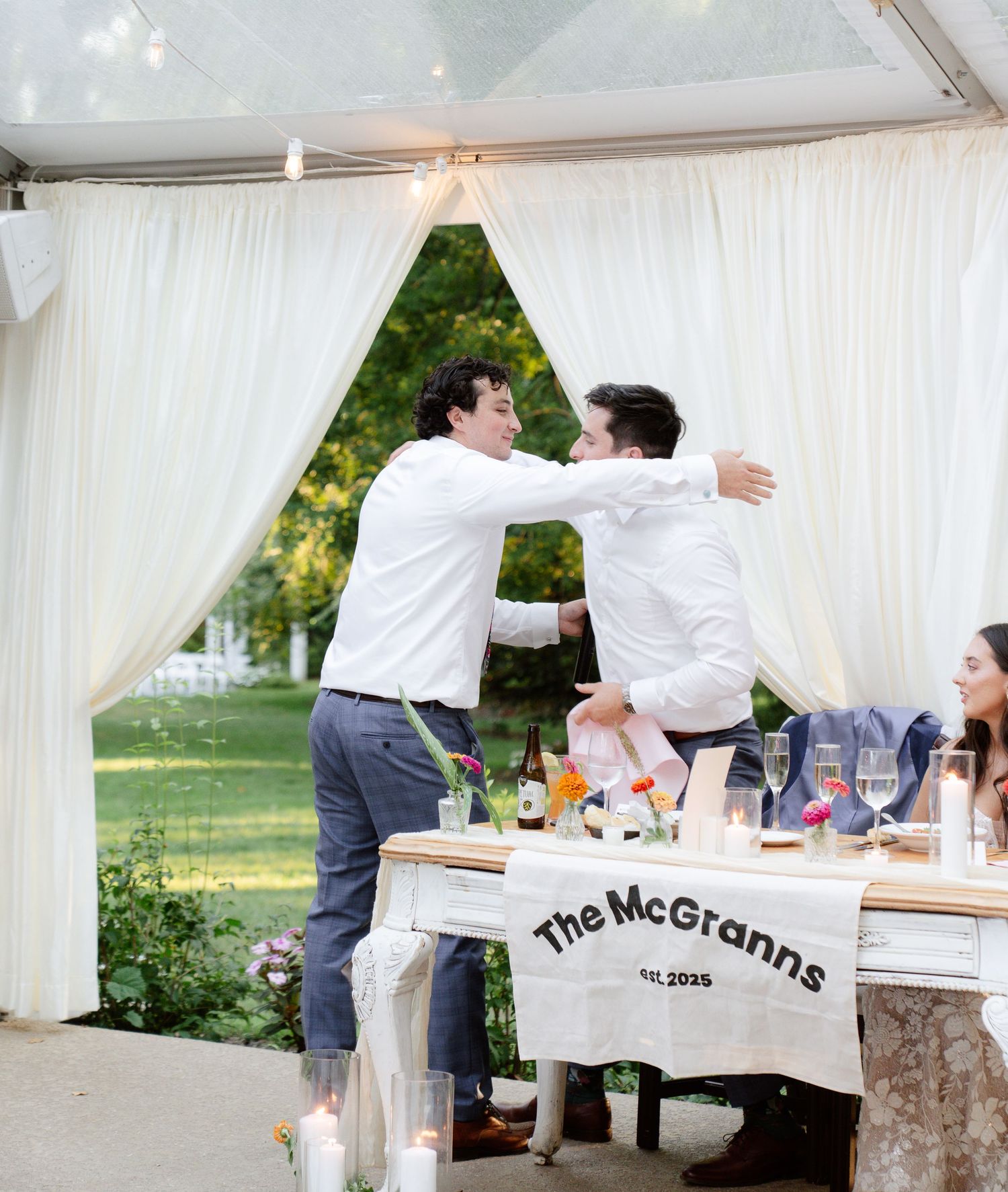Wedding reception setup with white draping and customized chair covers.