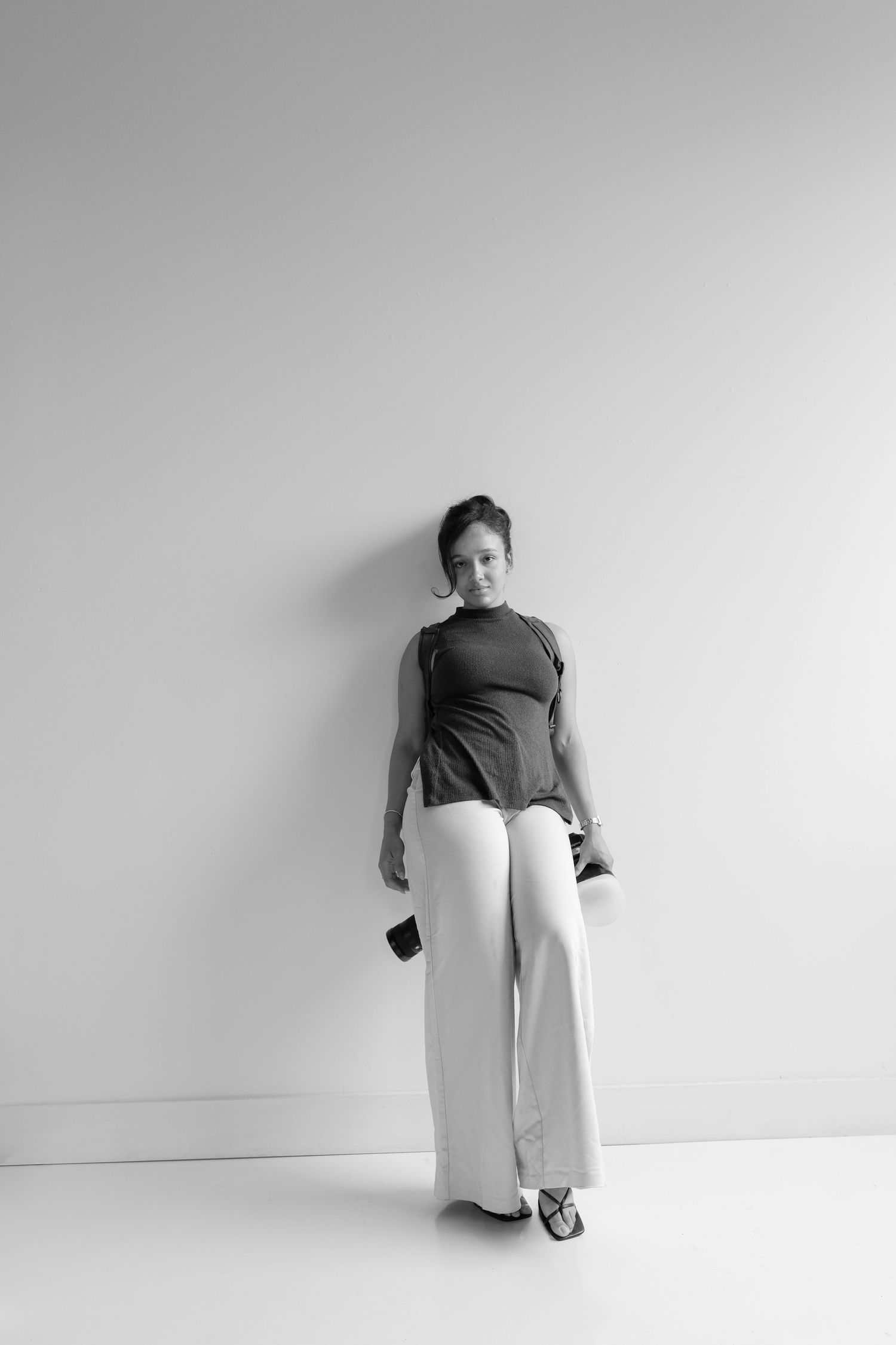 Artistic black and white portrait series showing movement against a minimalist backdrop.