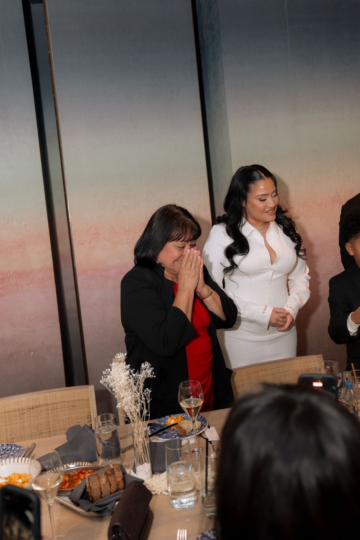 People gathered around a formal dining table during a celebration or event.