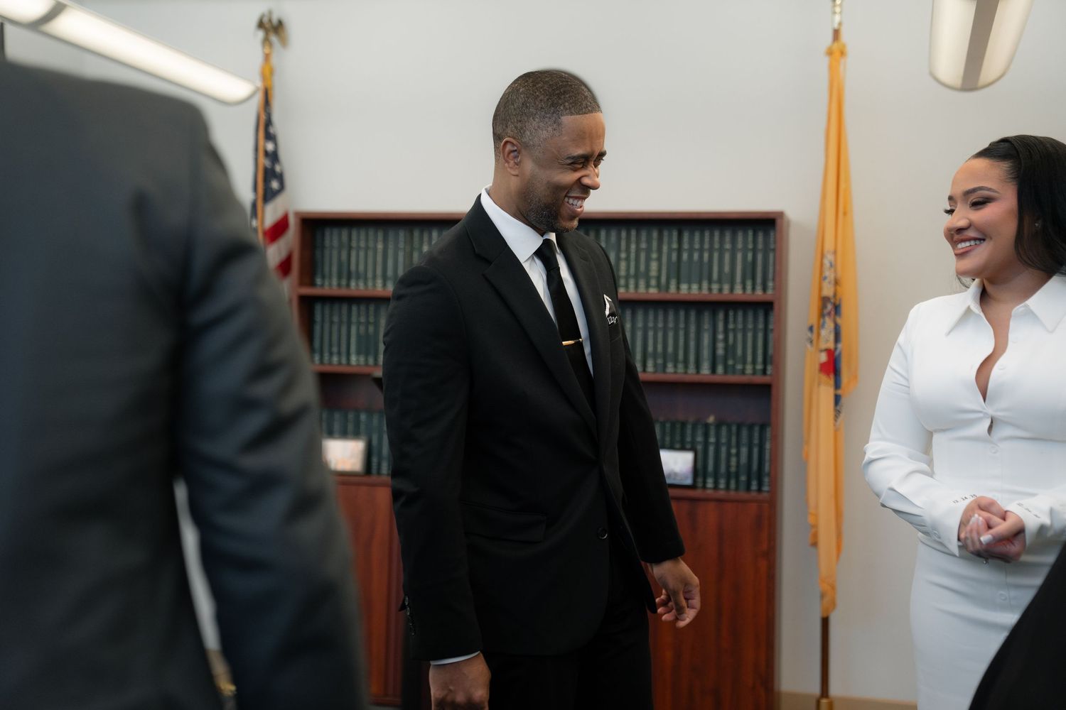 Professional ceremony taking place in an office setting with American flag and formal attire.
