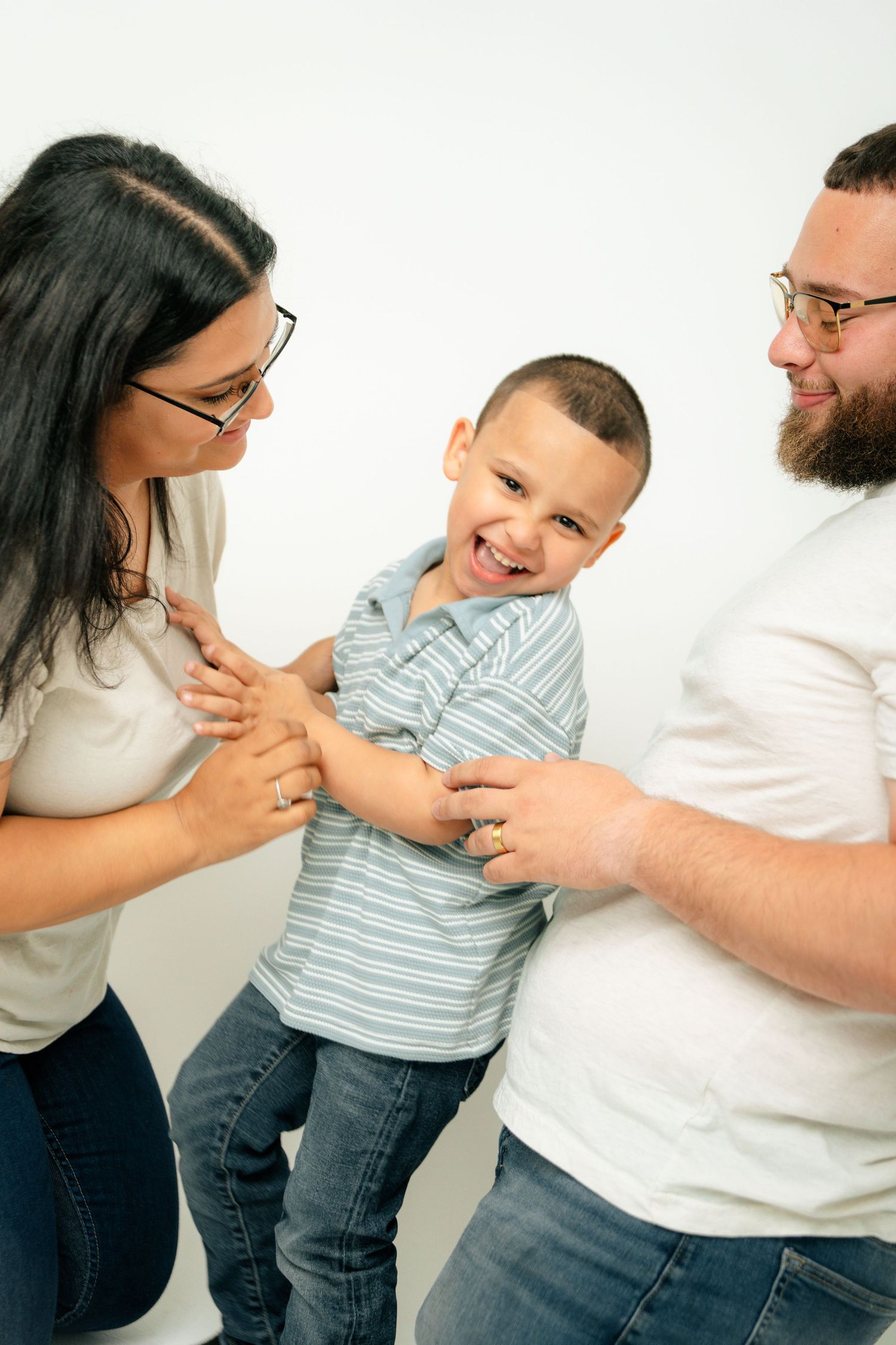 Playful family interaction sequence captured against white studio background.