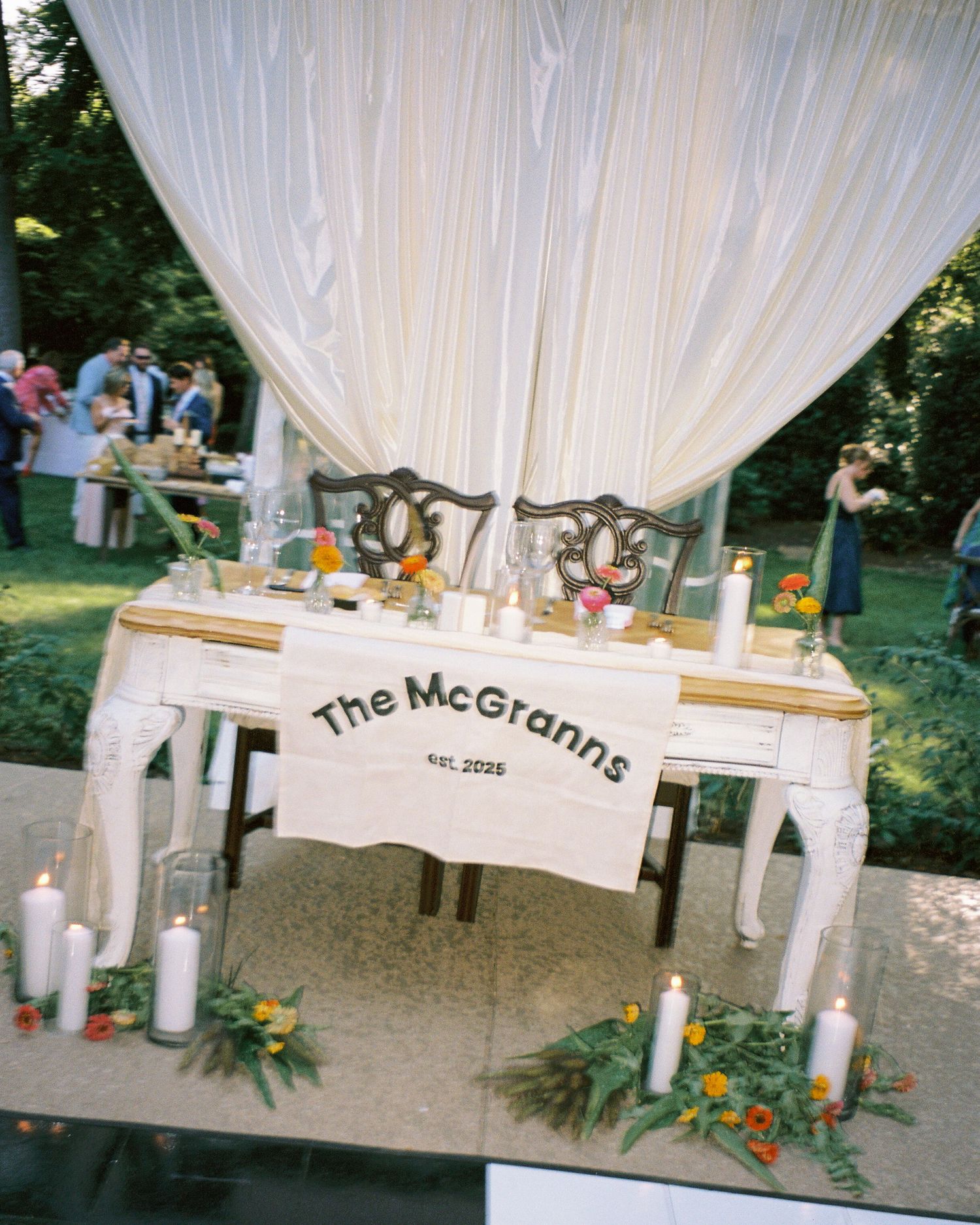 Wedding reception decor featuring white draping and personalized McGraths signage.