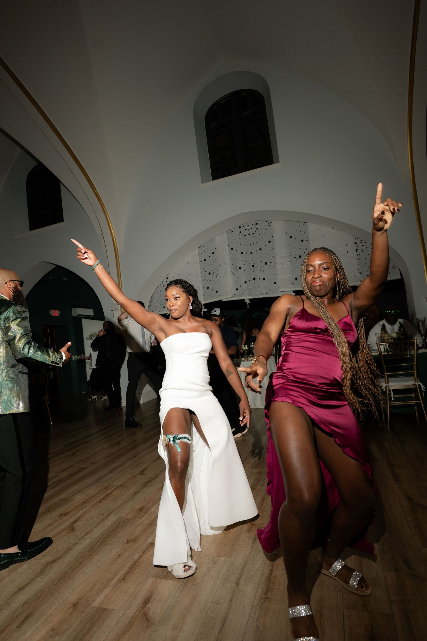 Energetic dancers performing dynamic moves on a wooden dance floor at an event.