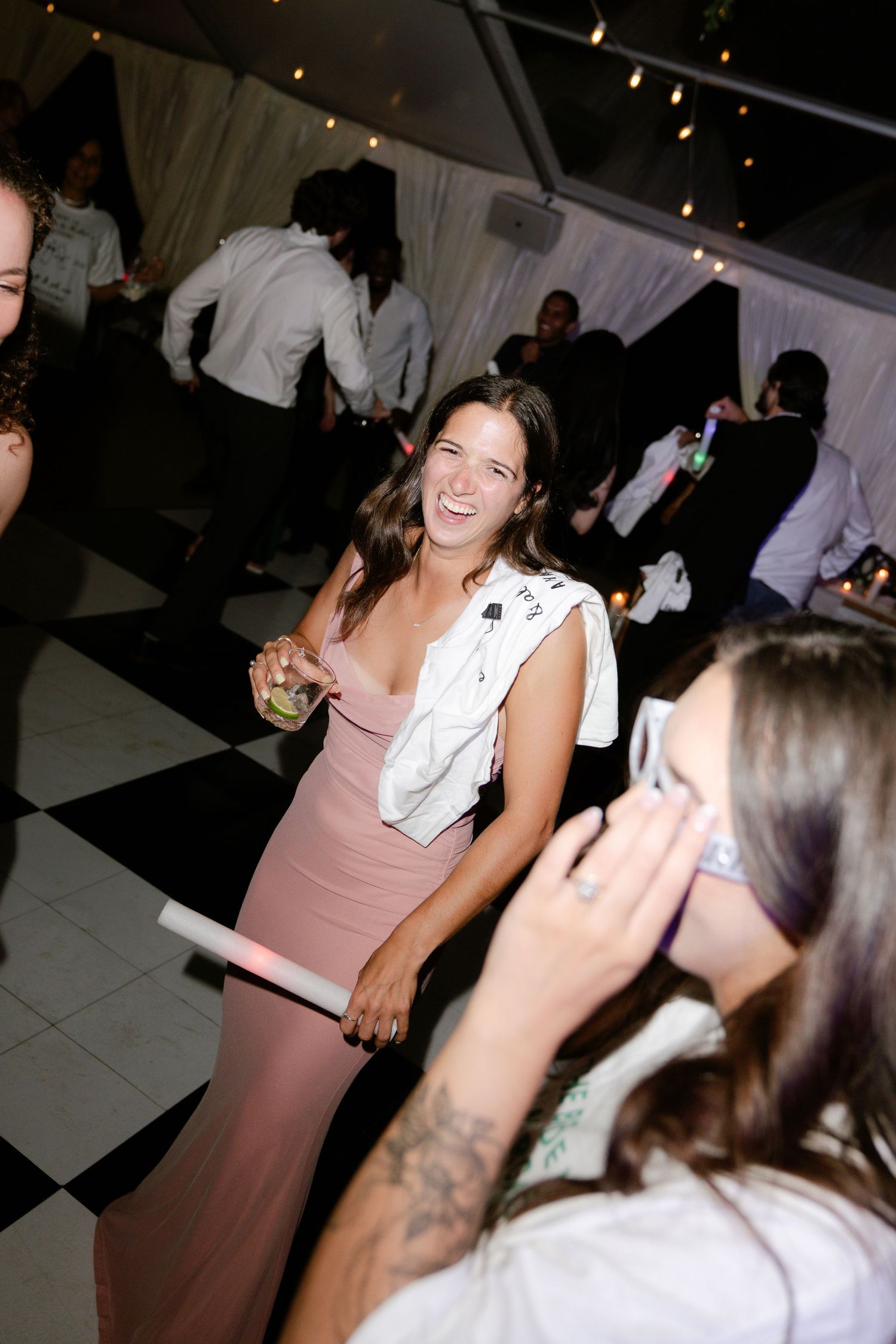 Wedding reception dance floor with guests celebrating under dim lighting.