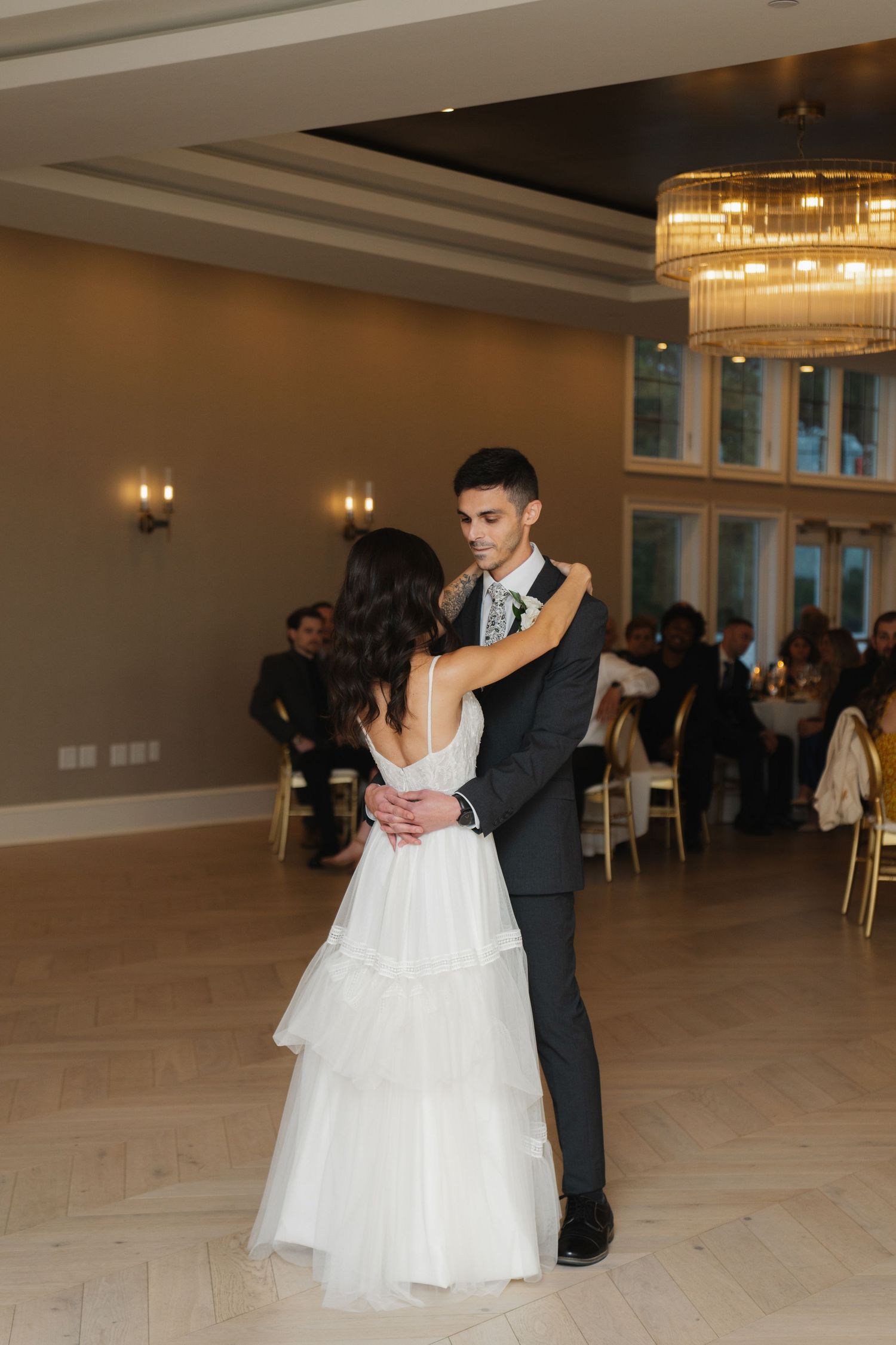 Newlywed couple shares a romantic dance together on the ballroom floor during their wedding reception.
