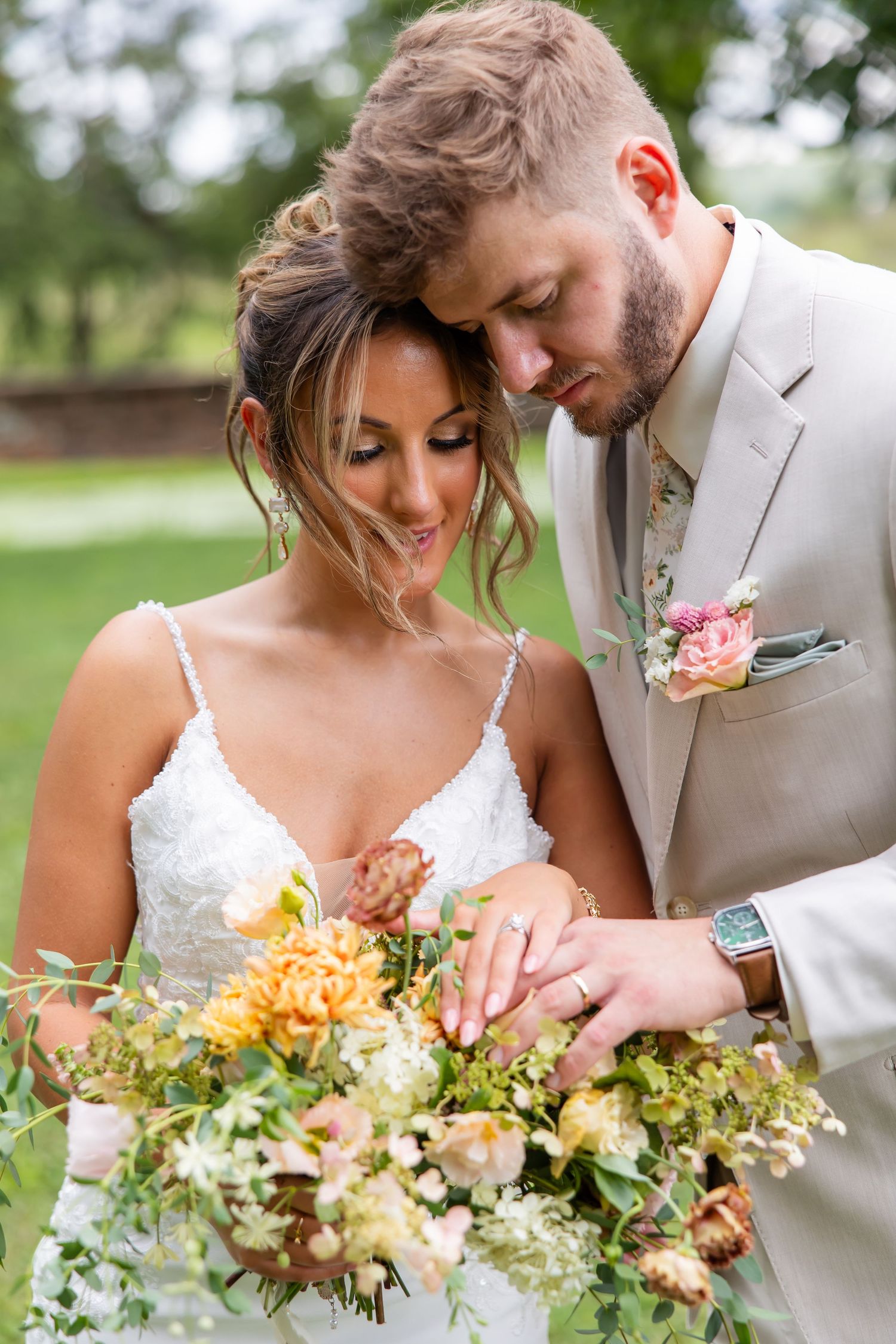 Groom leaning close to his bride as she holds her wedding bouquet.
