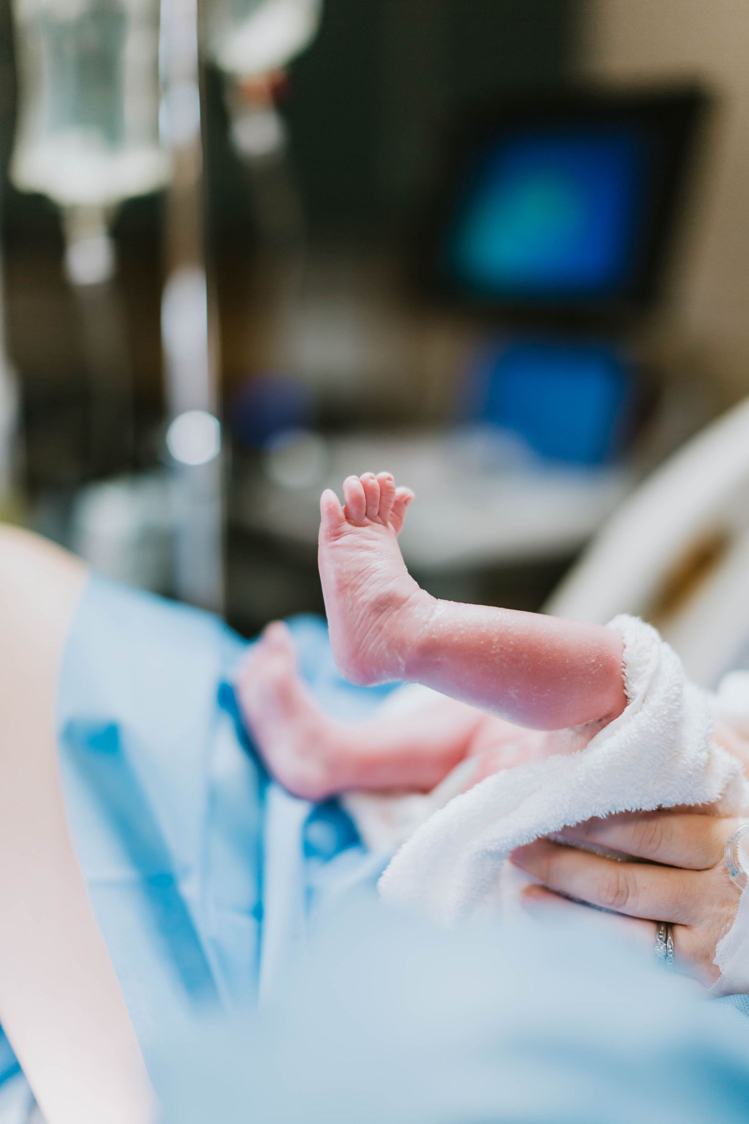 Tiny newborn feet held gently during the baby’s first moments in the hospital.