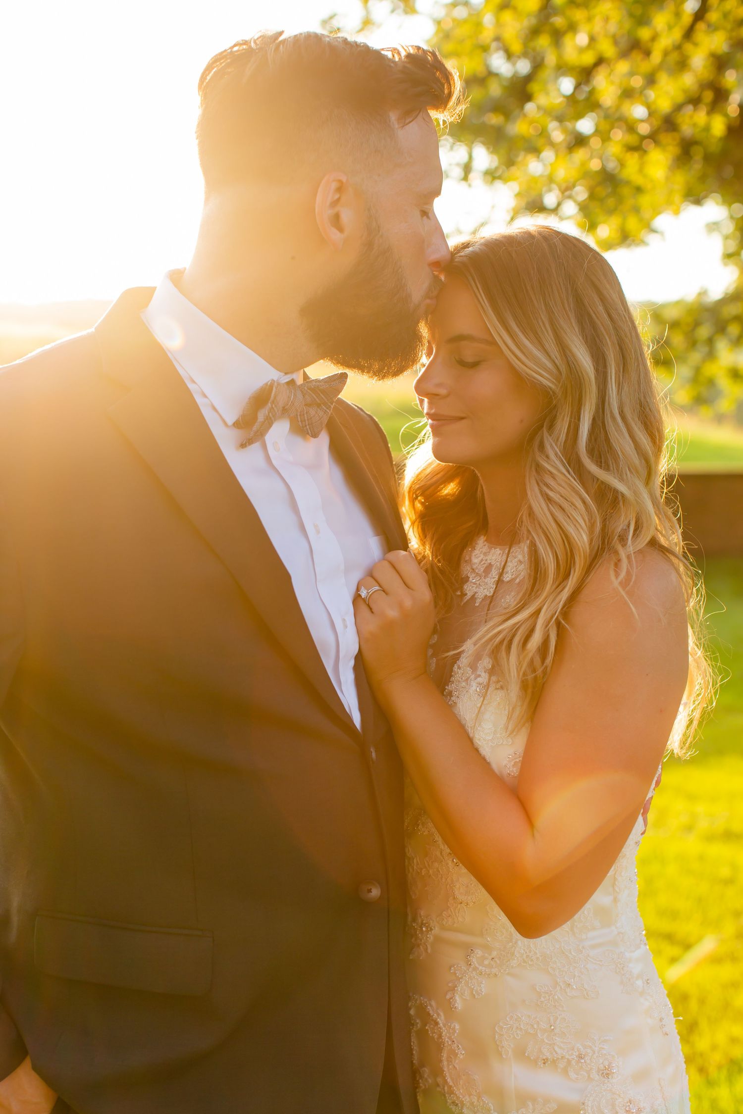 Couple sharing a close embrace in warm evening sunlight.