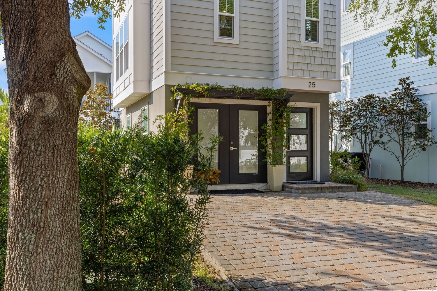 Coastal home exterior with brick driveway and greenery, photographed by Coast Captured Real Estate Photography in Santa Rosa Beach FL