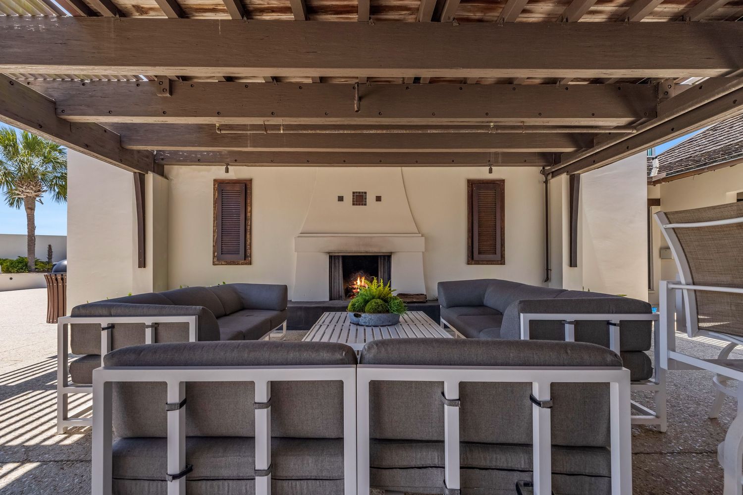 Outdoor entertainment area with fireplace and seats, captured by Coast Captured for 30A real estate marketing and coastal lifestyle listings