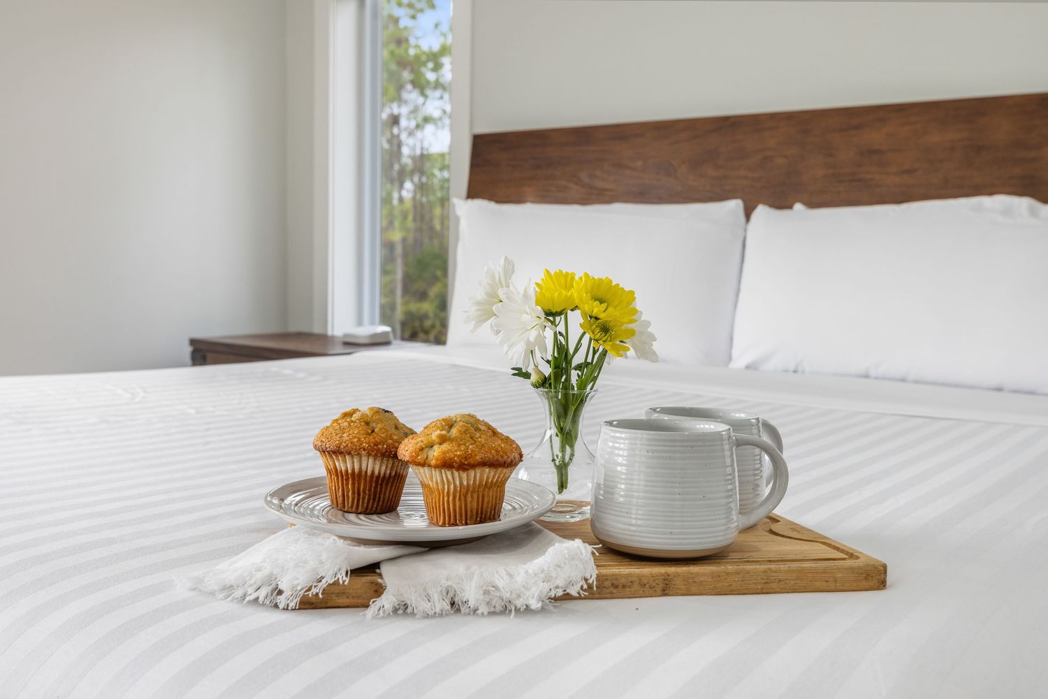 Bright bedroom with natural light and cozy breakfast tray, photographed for Emerald Coast real estate listing by Coast Captured
