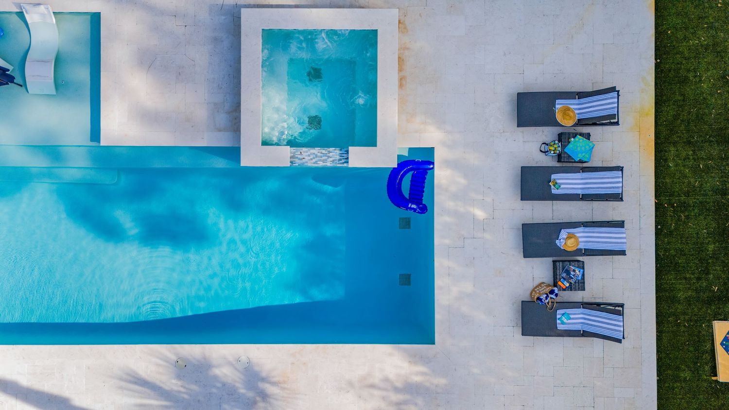 Aerial drone photo of modern pool and loungers in Florida home, captured by Coast Captured for Emerald Coast real estate listing