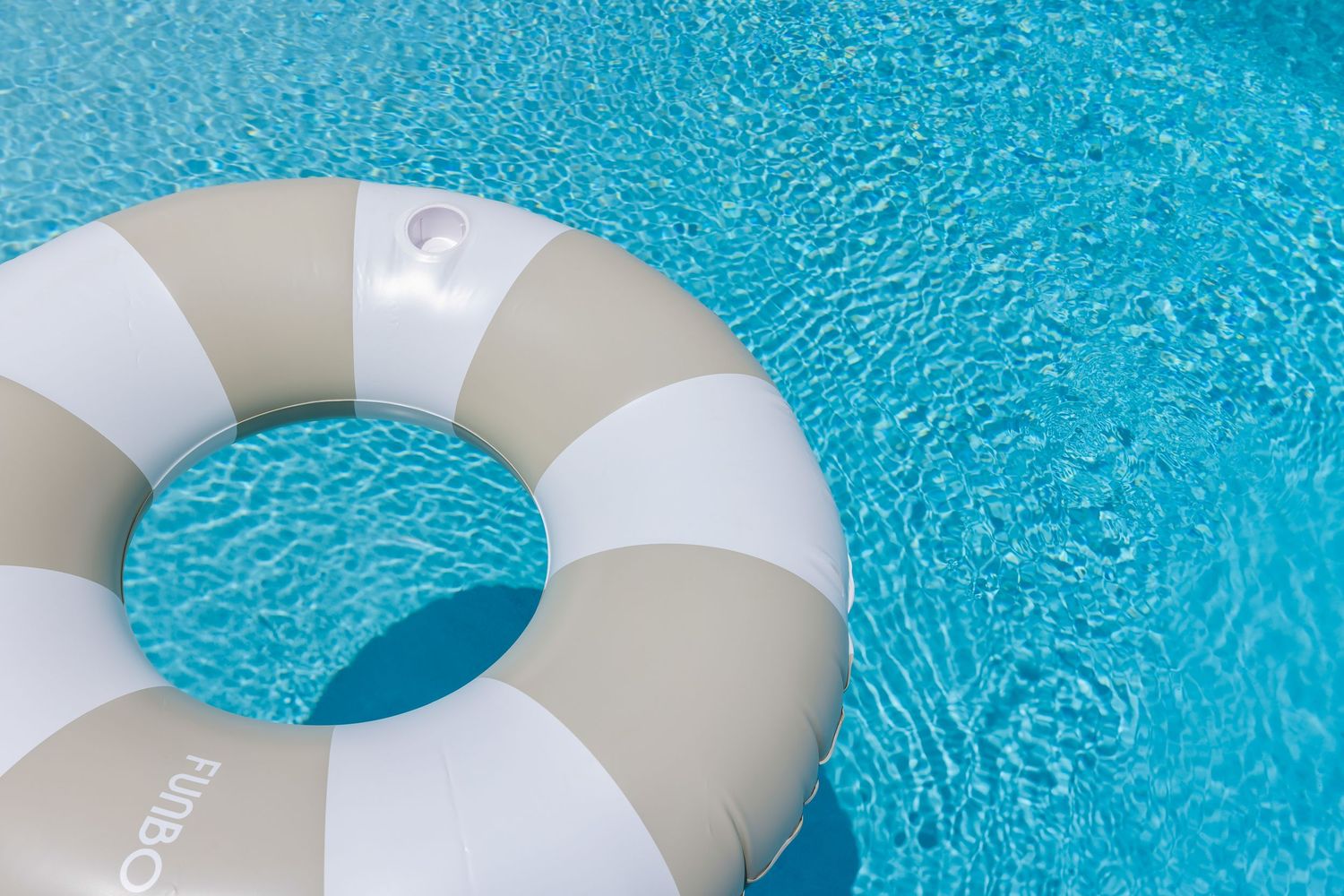 Pool float in clear turquoise water, bright summer detail photo by Coast Captured Real Estate Photography on Florida’s Emerald Coast