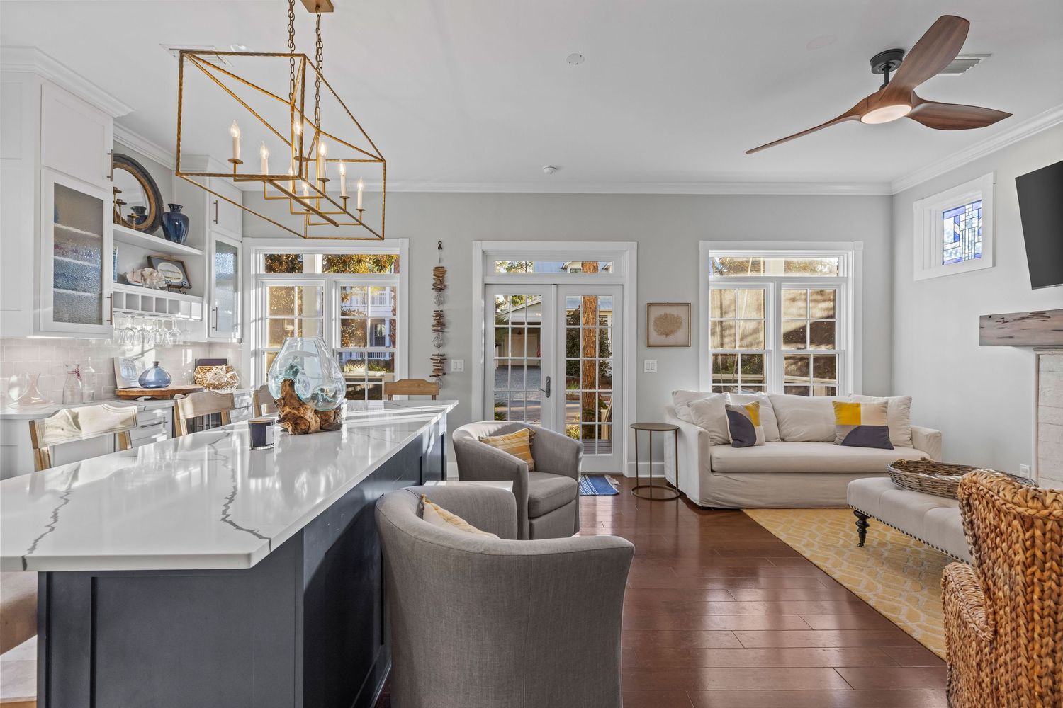 Open kitchen and dining area with pendant lights and neutral coastal design, photographed for real estate marketing on the Emerald Coast