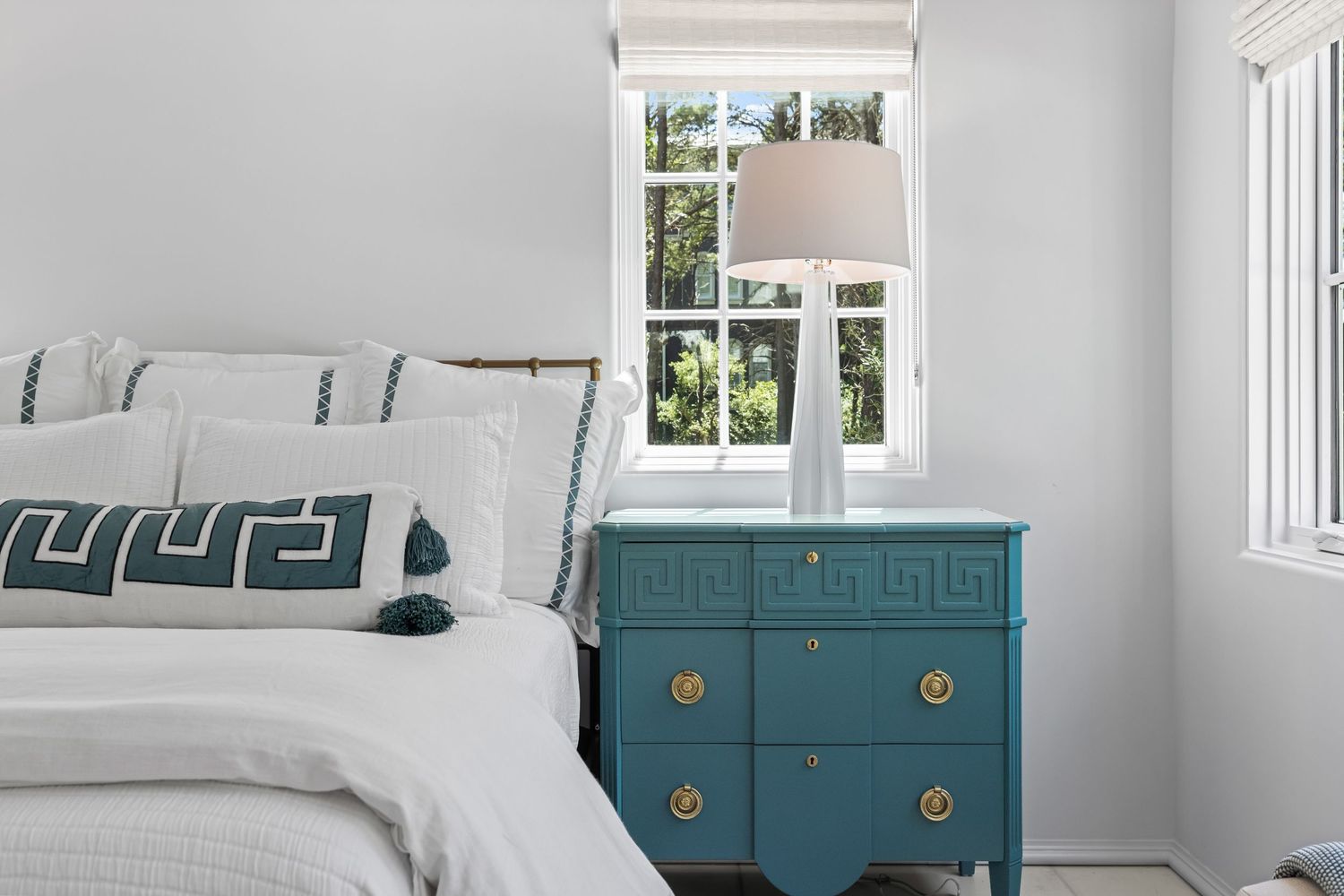 Coastal bedroom with white bedding and blue nightstand, natural light interior photo by Coast Captured Real Estate Photography