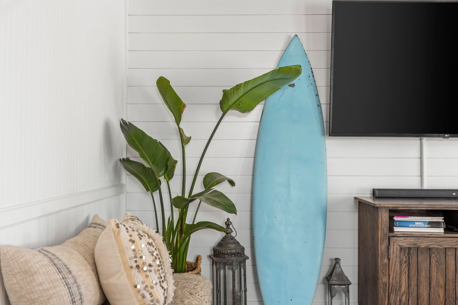 Coastal living room corner with surfboard décor and natural textures, lifestyle detail by Coast Captured 30A Real Estate Photography