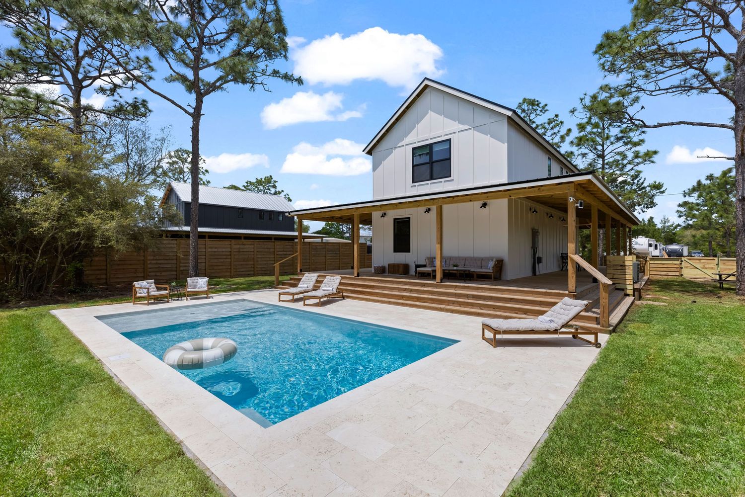 Backyard with private pool and deck area surrounded by pines, photographed by Coast Captured for Florida real estate listing