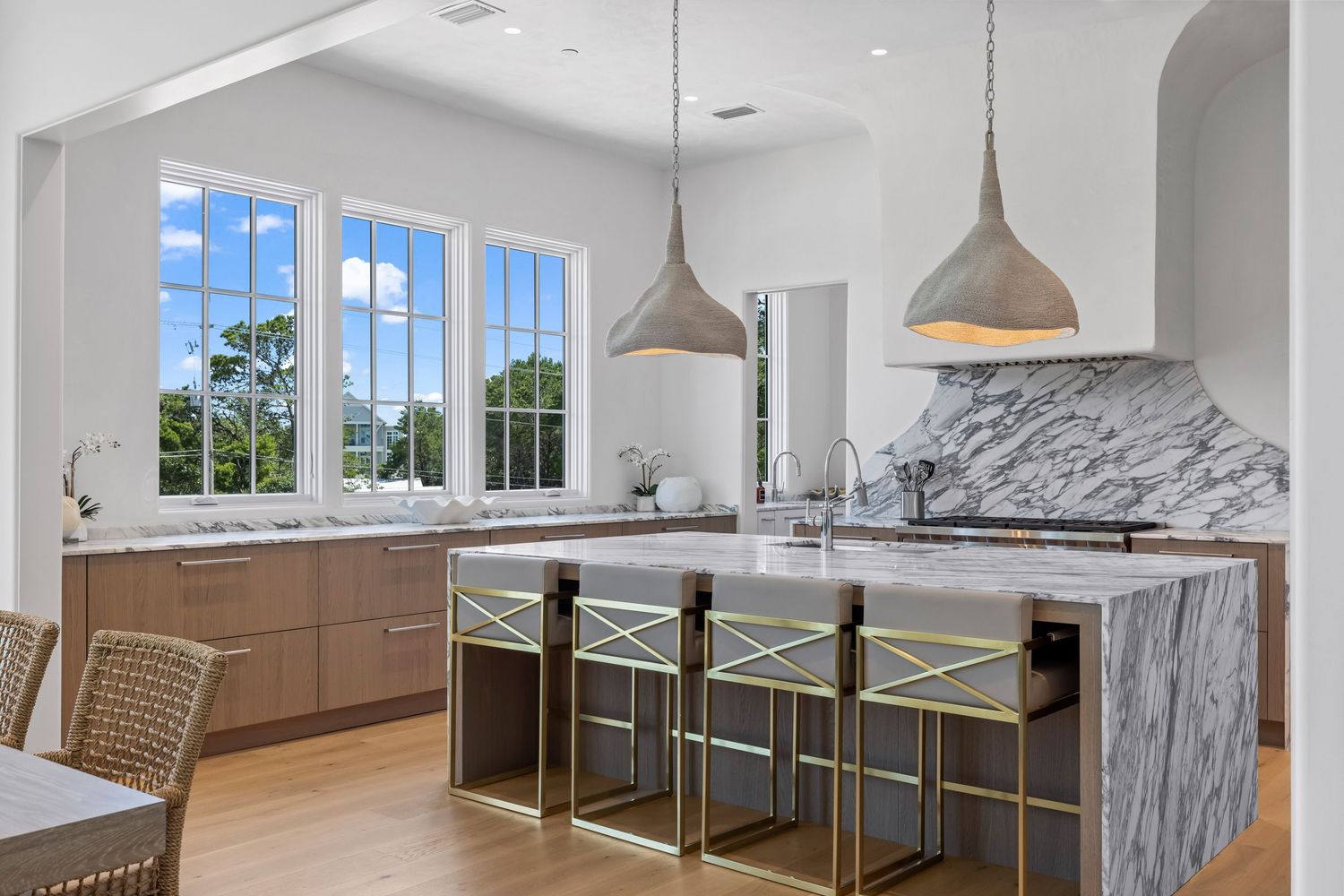 Open kitchen and dining space with marble island and pendant lighting, photographed by Coast Captured Real Estate Photography