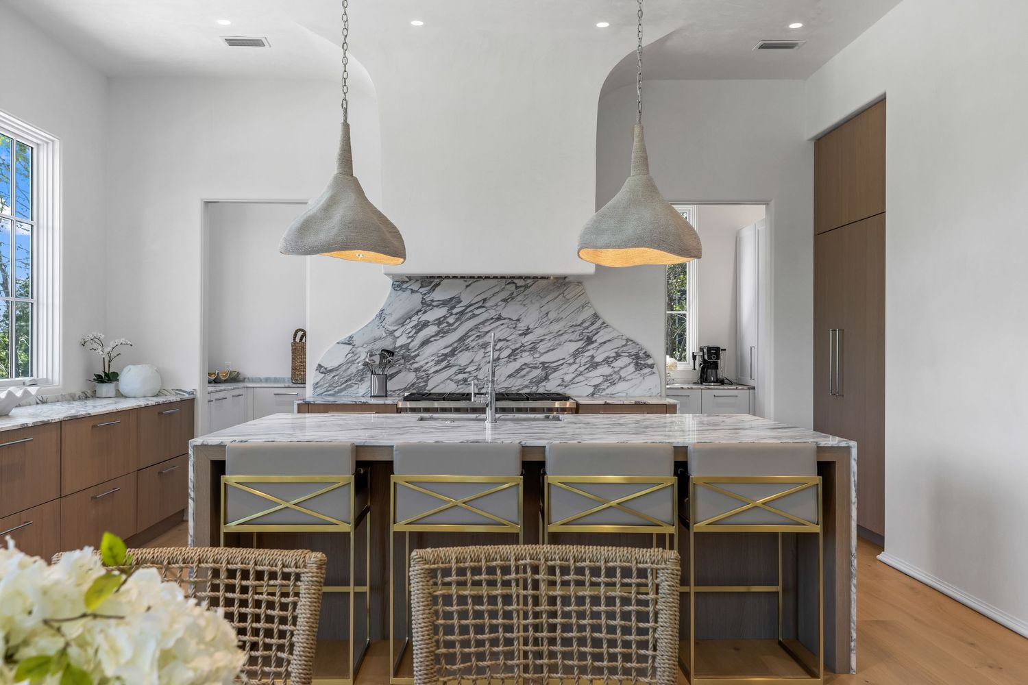 Luxury kitchen with marble backsplash and pendant lighting, interior photo by Coast Captured for Emerald Coast real estate marketing