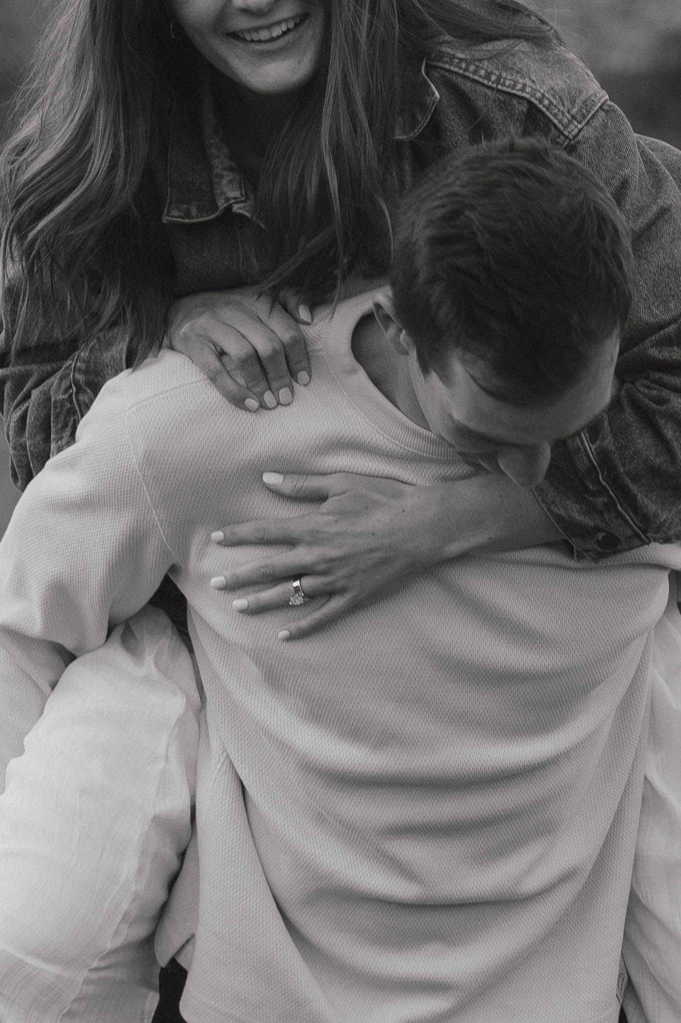 A series of black and white photos showing a couple embracing in casual clothing with natural lighting.
