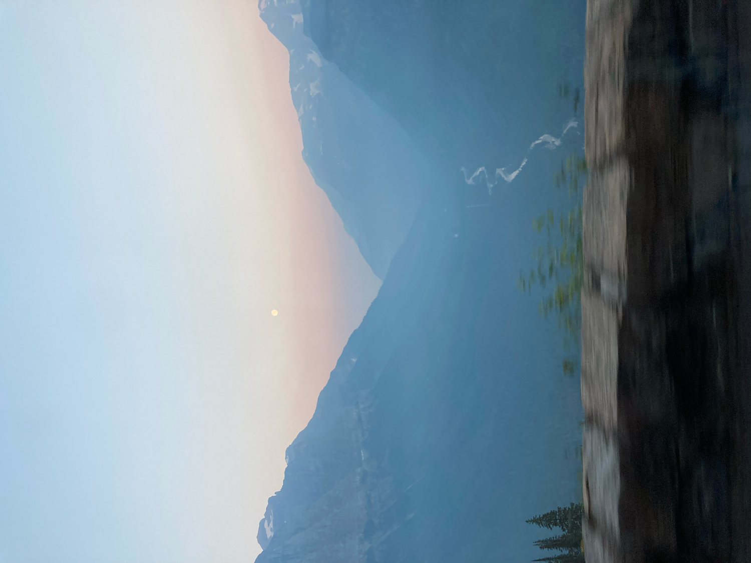 Misty Colorado mountain valley at sunset with winding river below.