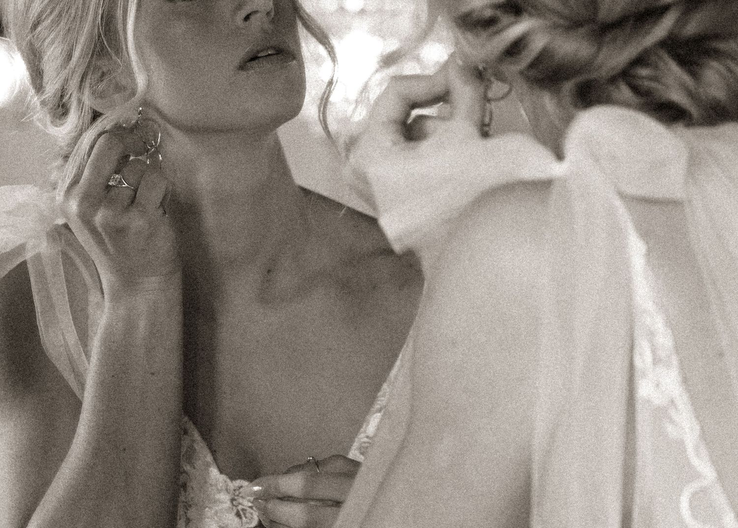 Artistic black and white close-up portrait showing delicate side profile with ethereal lighting on wedding day.