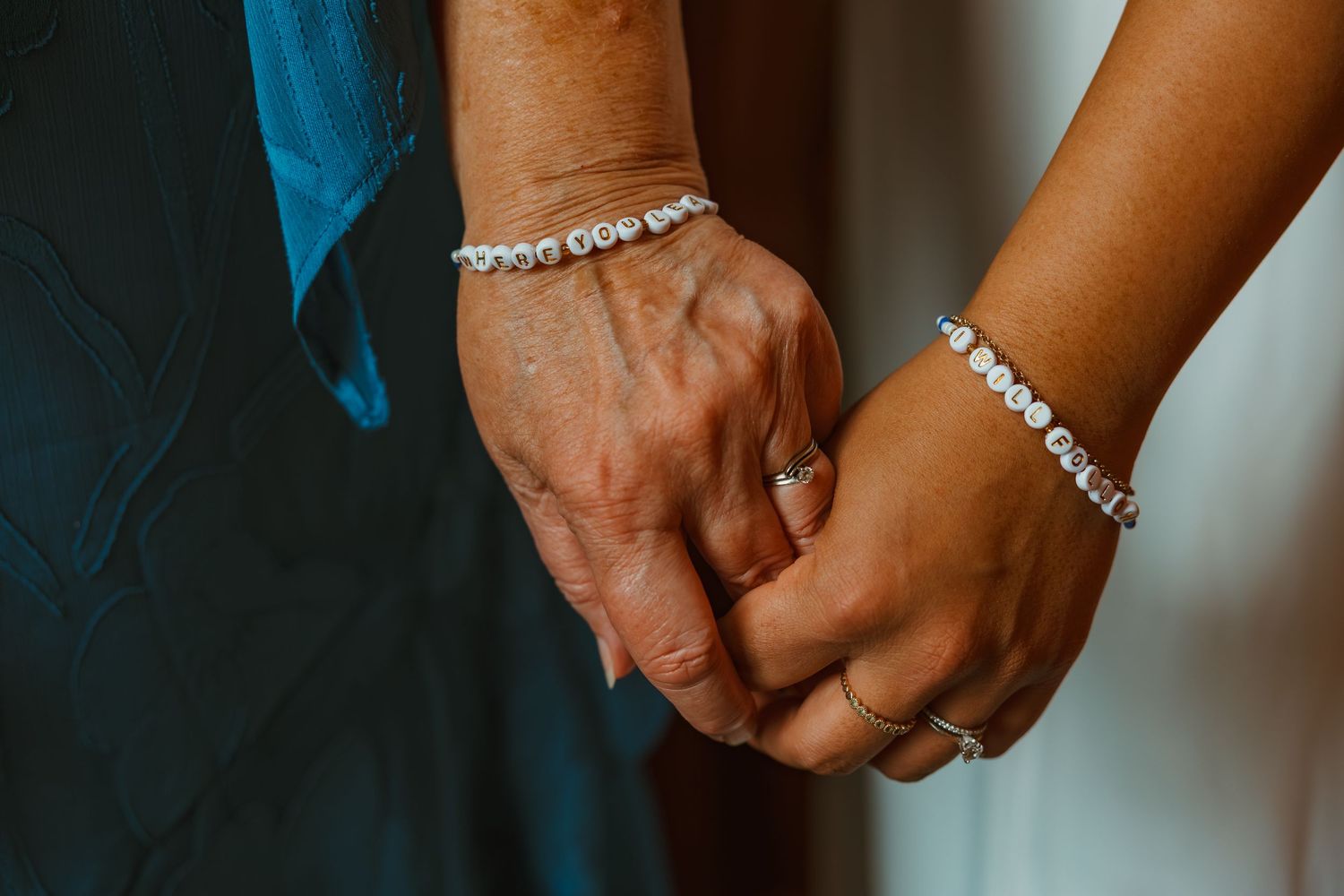 Two women holding hands wearing diamond tennis bracelets. Michigan elopement.