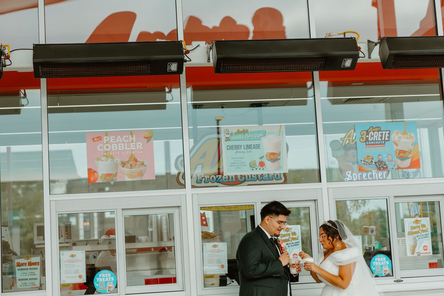 Bride and groom sharing a sweet moment eating together outside a fast food restaurant in wedding attire. Chicago weddings.
