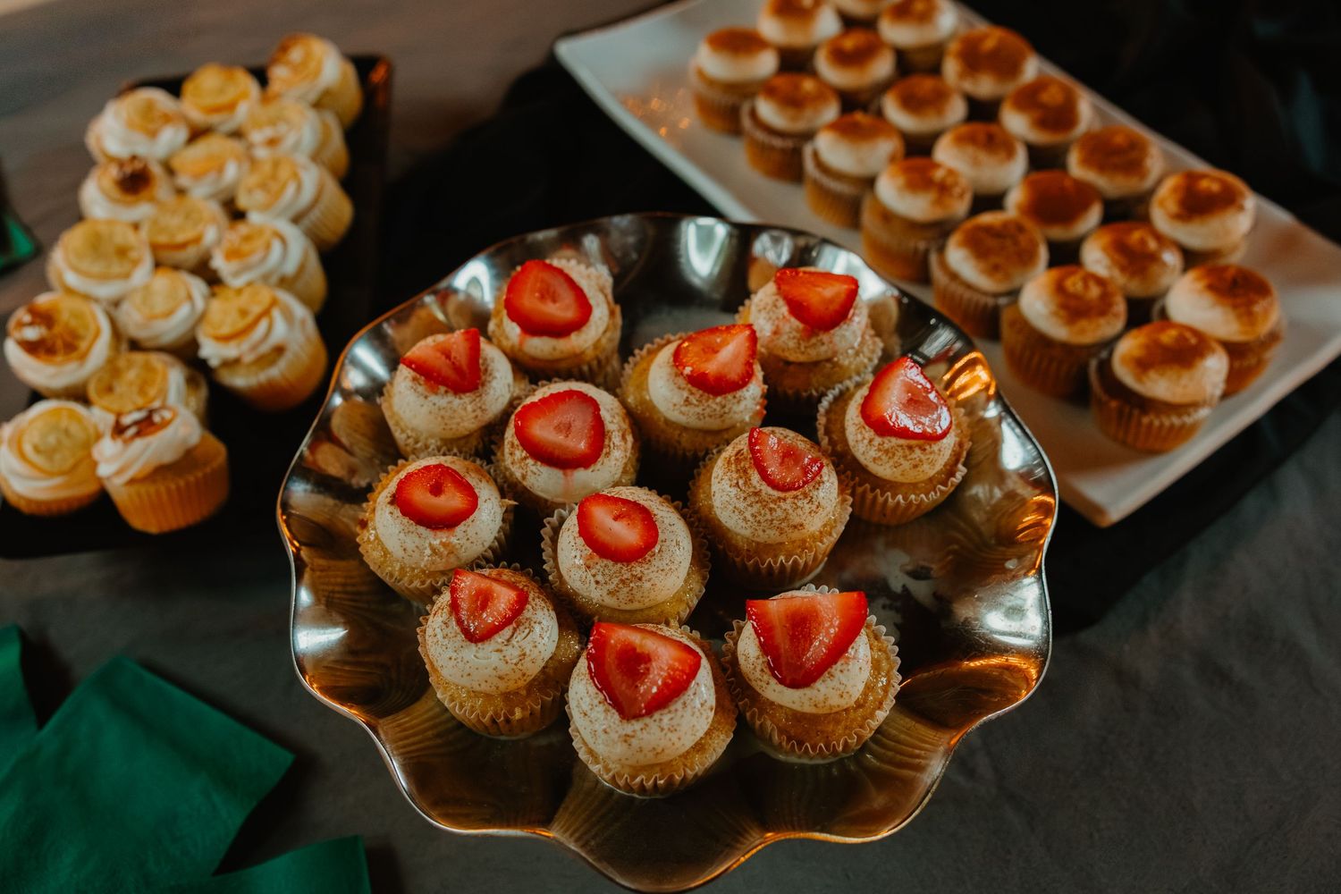 Elegant wedding dessert display featuring strawberry topped cupcakes and mini pastries on silver tray. Northwest Indiana wedding venues.