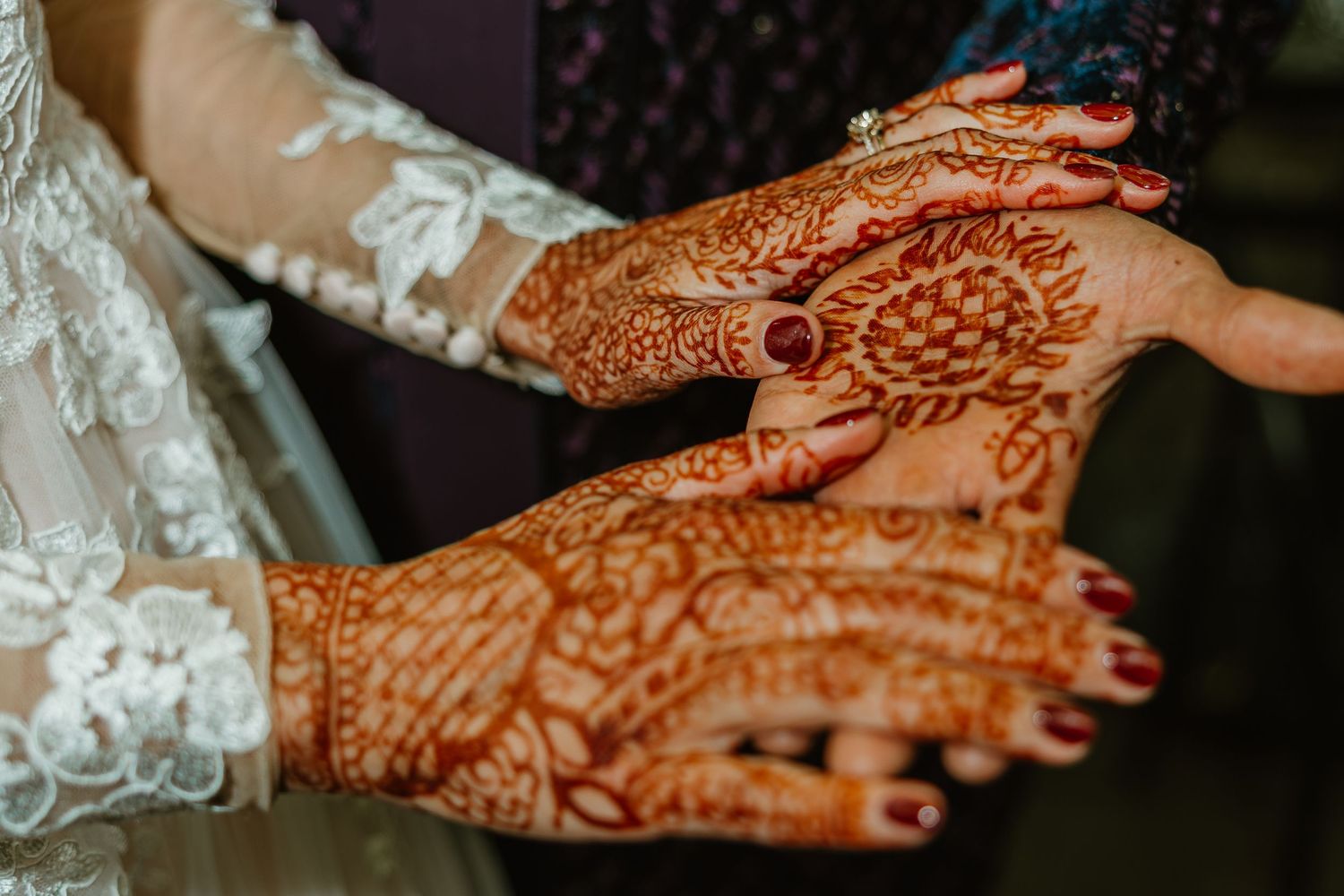 Close-up of intricate henna mehndi designs on the hands of a bride on her wedding day. Documentary style wedding photos.