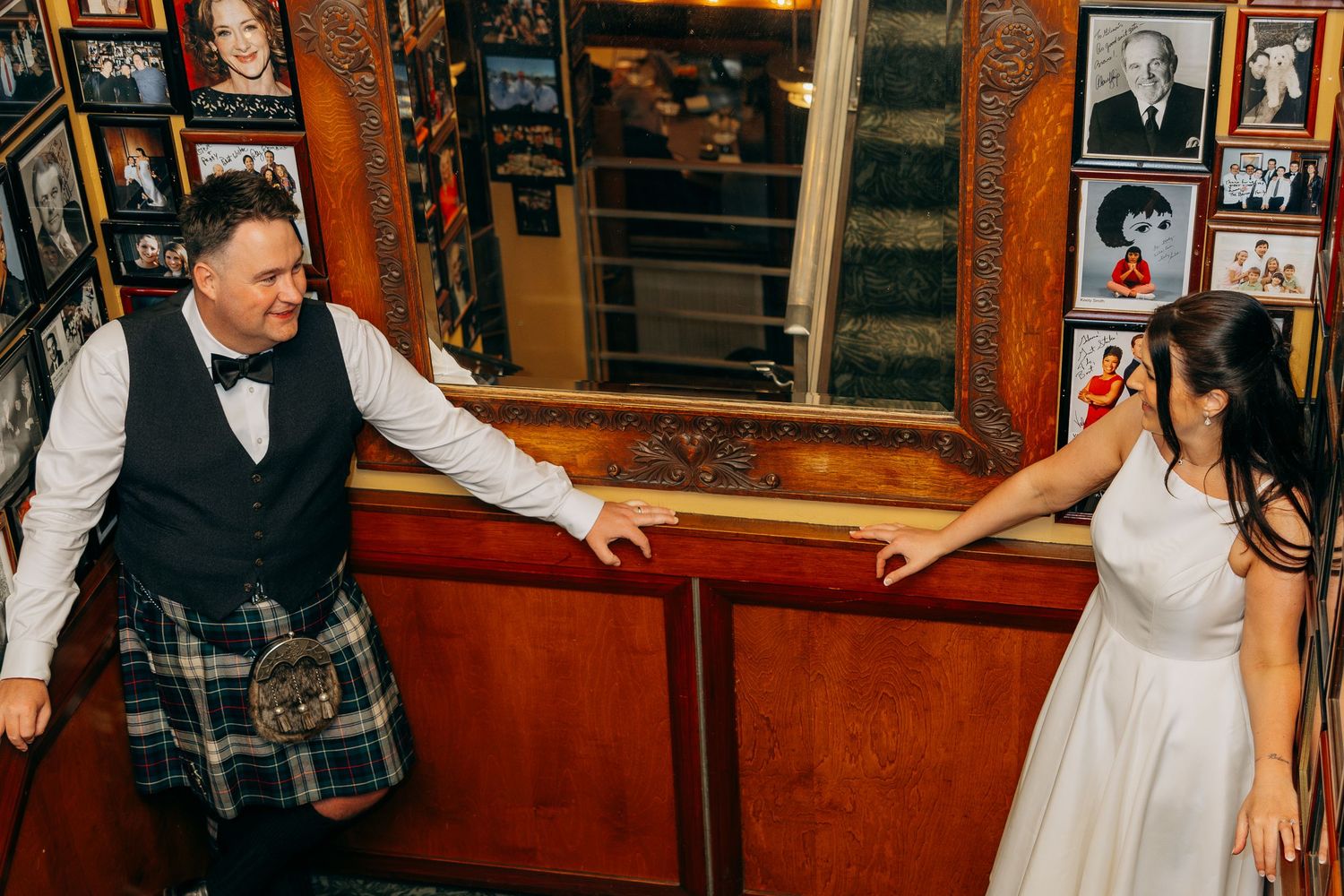 Bride and groom in kilt dancing in decorated bar with photos. Chicago wedding reception Gibson's Bar and Steakhouse.