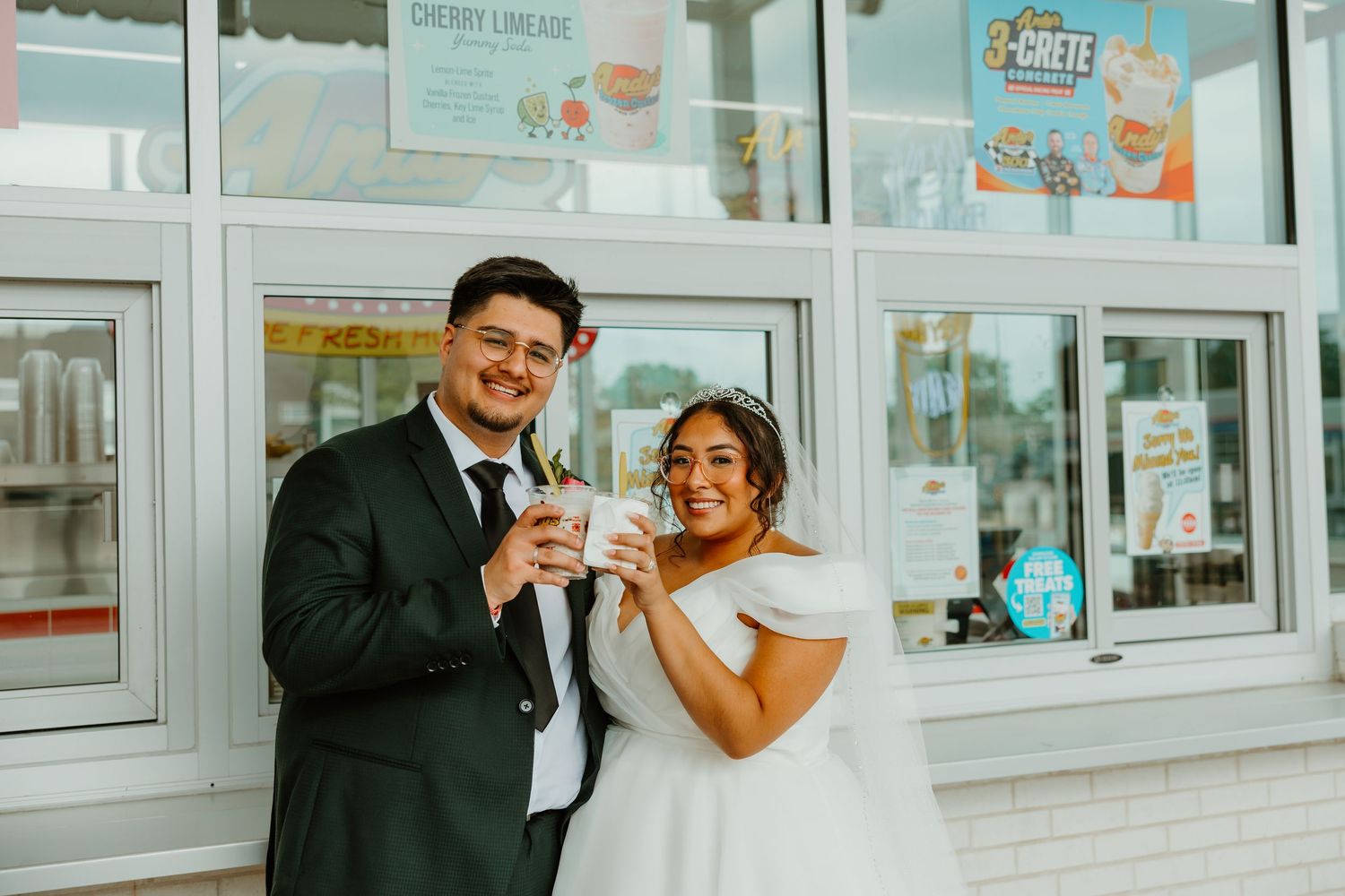 Newlywed couple smiling and holding ice cream cups outside a Sonic Drive-In on their wedding day. Chicago weddings.