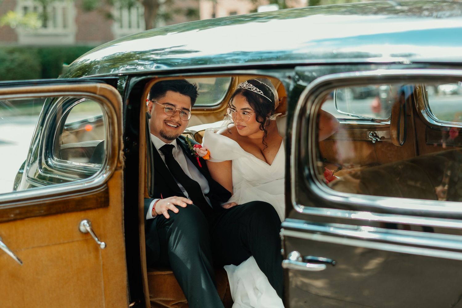 Bride and groom smiling inside a vintage classic wedding car on their special day. Chicagoland weddings.