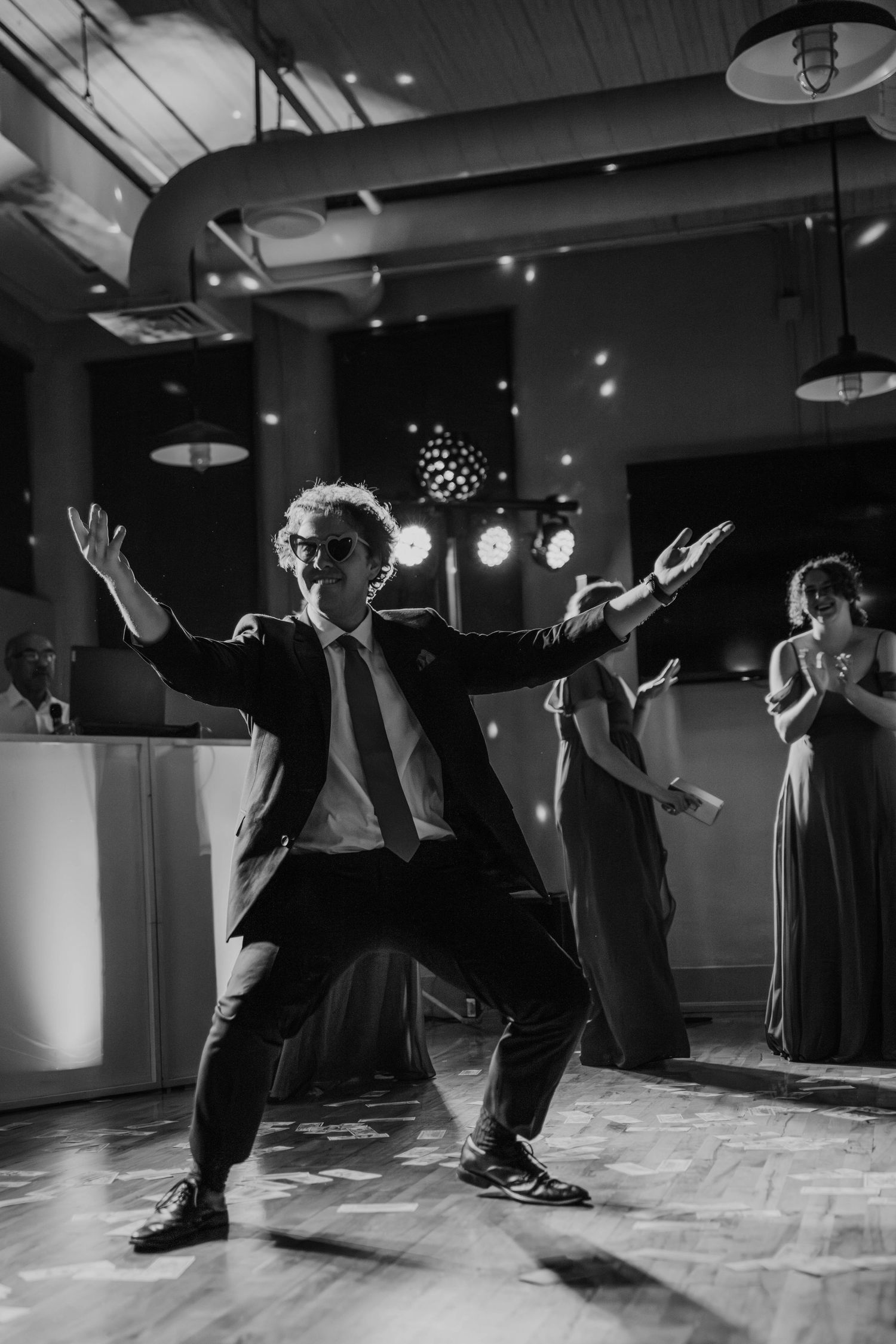 Black and white photo of a guest dancing energetically on the wedding reception dance floor.