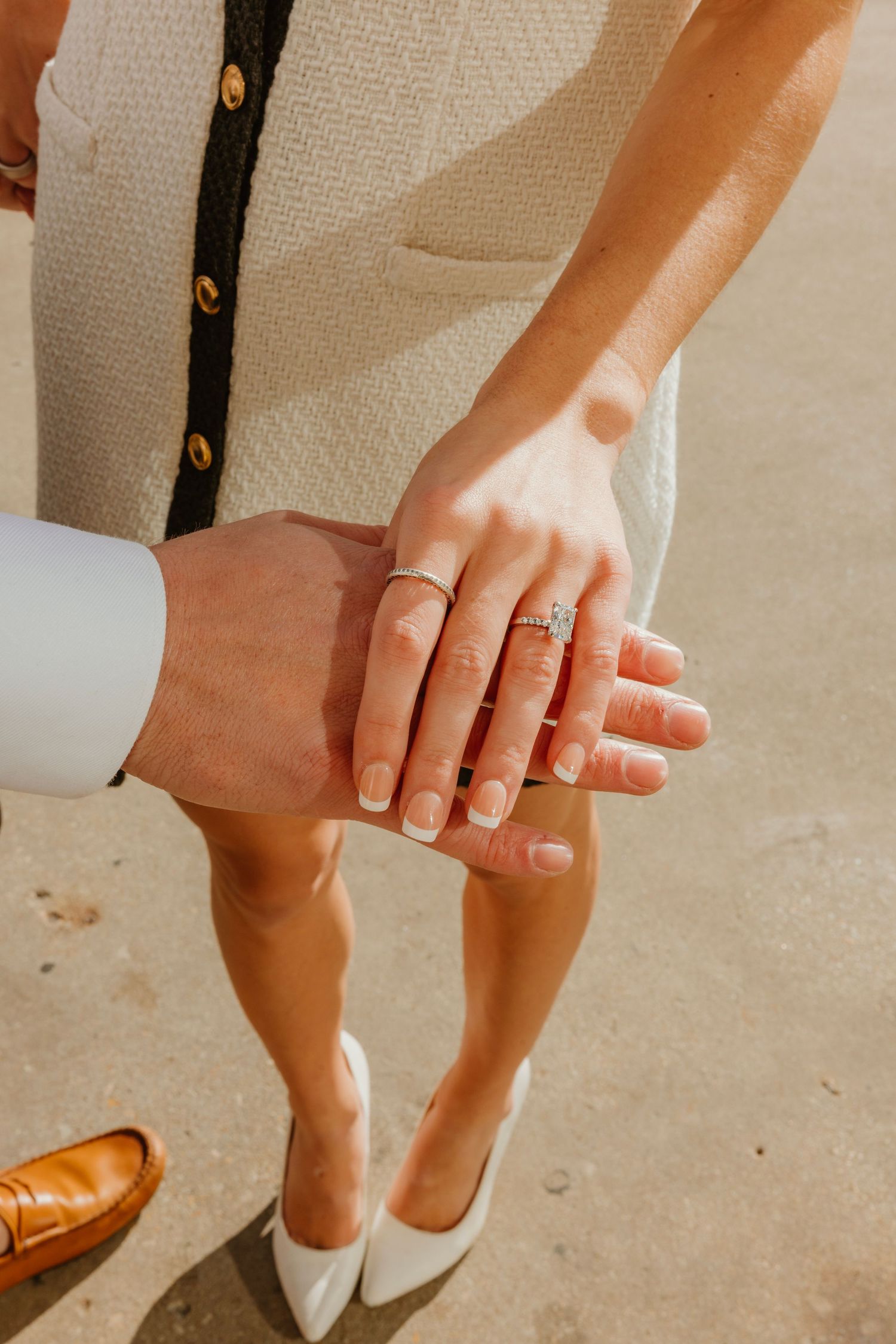 Close-up of couple holding hands showing diamond engagement ring outdoors. Outdoor Chicago engagement photos.