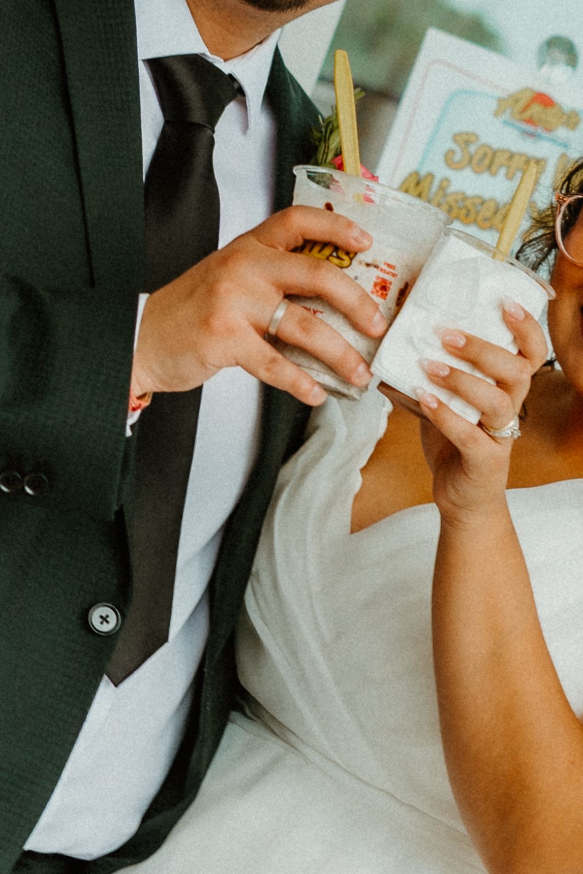 Bride and groom toasting with iced drinks in decorated cups at their wedding reception. Chicago weddings.