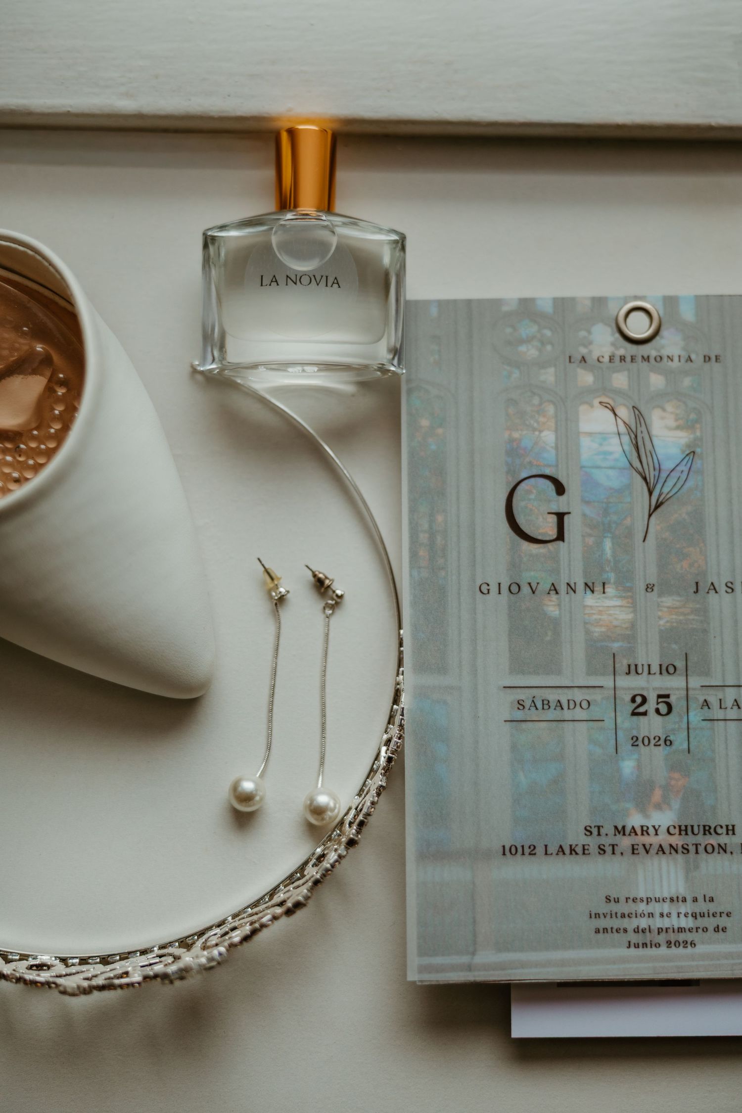 Elegant wedding flat lay with invitation, pearl earrings, necklace, and La Novia perfume. Chicagoland weddings.
